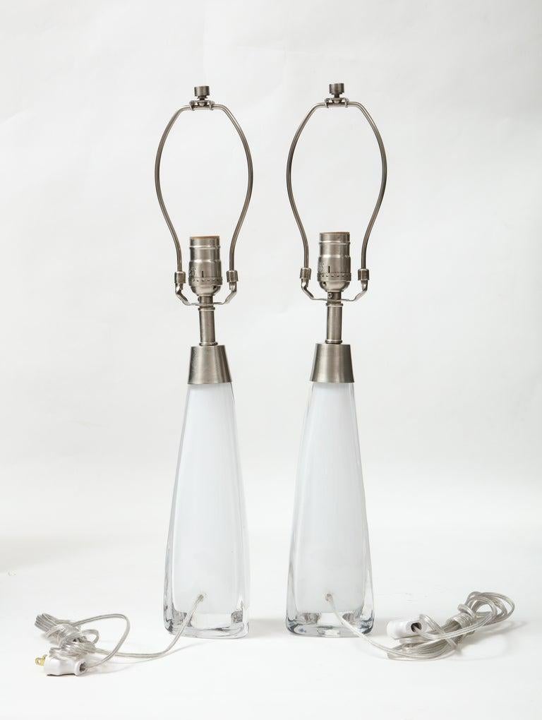 Ein Paar moderne skandinavische Lampen aus weißem Kristall mit dreieckigem Sockel und satinierten Nickelbeschlägen. Für die Verwendung in den USA umverdrahtet, max. 100 W Glühbirnen.