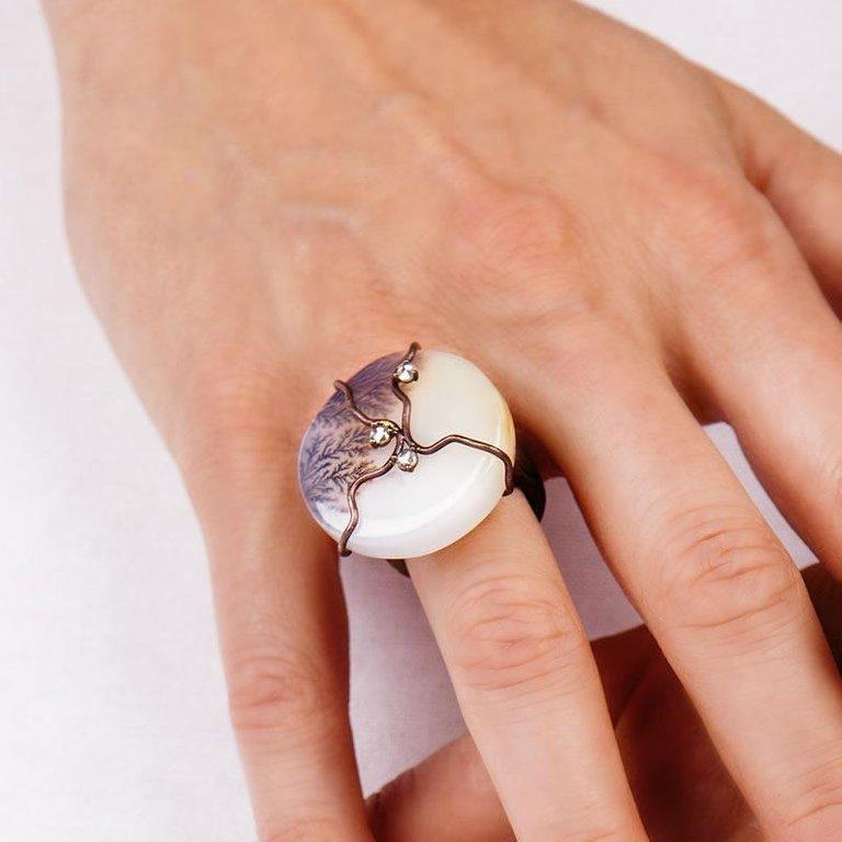 The ring is designed to emphasize an excellent moss white moss agate, with brown, very fine dendritic inclusions.

The shank which supports the stone is cast in titanium, with a gold-tinted silk-effect satin finish, to match the colors of the