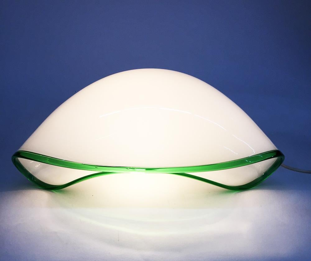 'Orsera' table lamp by Vistosi Vetreria, Italy 1970s

Table lamp, 'Orsera' designed and manufactured by Vistosi, Murano, Italy
White glass with clear green rim
Etched name in the glass by Vistosi

The measurement is 22 cm high, 48.5 cm wide and the