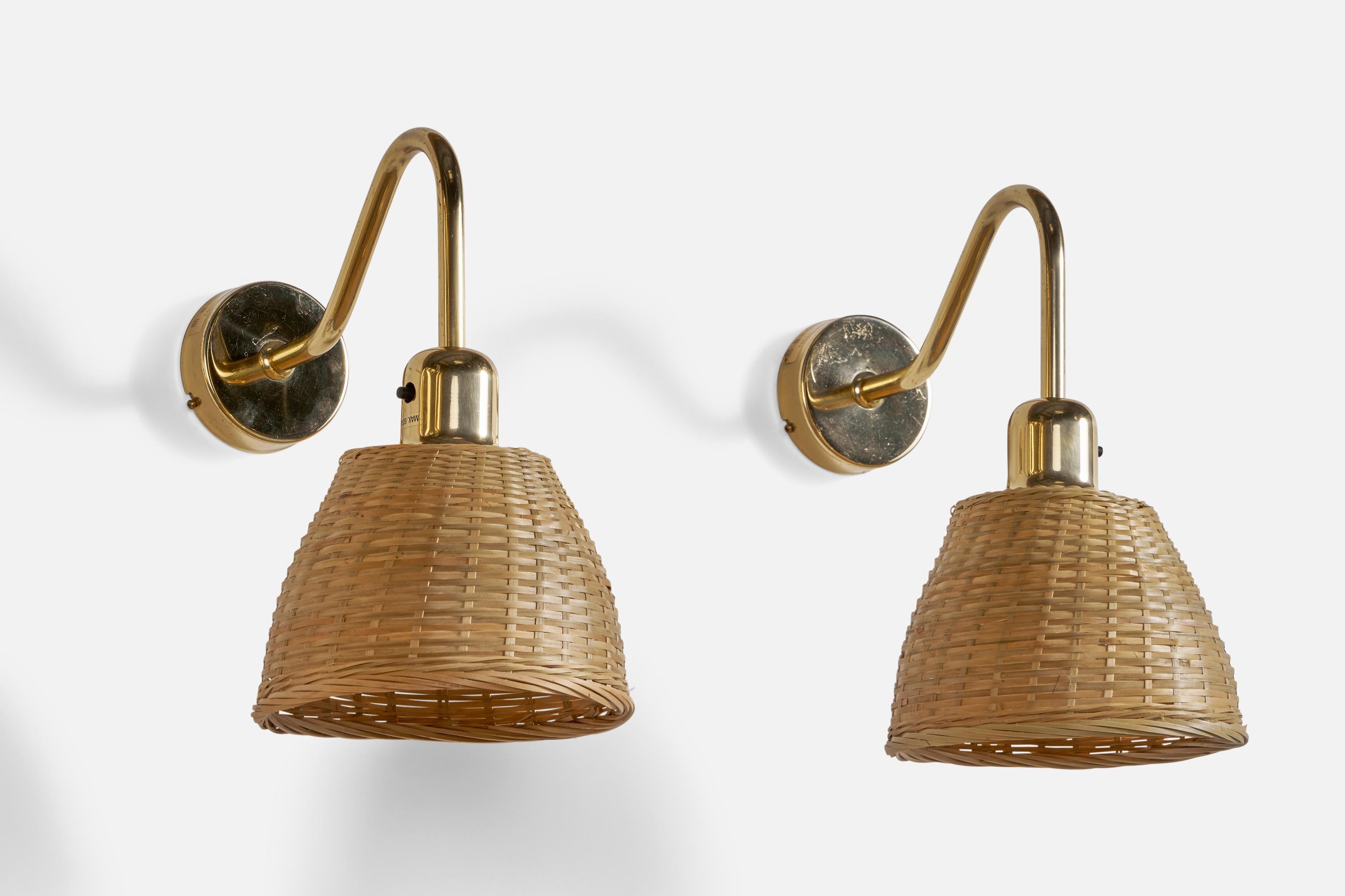 A pair of brass and rattan wall lights designed and produced by Orsjö Belysning, Sweden, c. 1970s.

Overall Dimensions (inches): 12” H x 7” W x 12” D
Back Plate Dimensions (inches): 3.36” Diameter x 1” Depth
Bulb Specifications: E-26 Bulbs
Number of