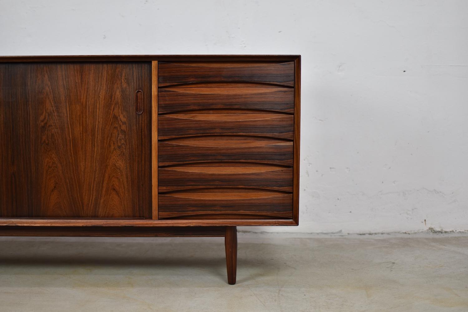 Lovely OS29 sideboard by Arne Vodder for Sibast, Denmark, 1950s. This rare cabinet is made out of rosewood and has two sliding doors and a series of marvelous curved drawers. Typical raised edge on the top and overall in very good original condition