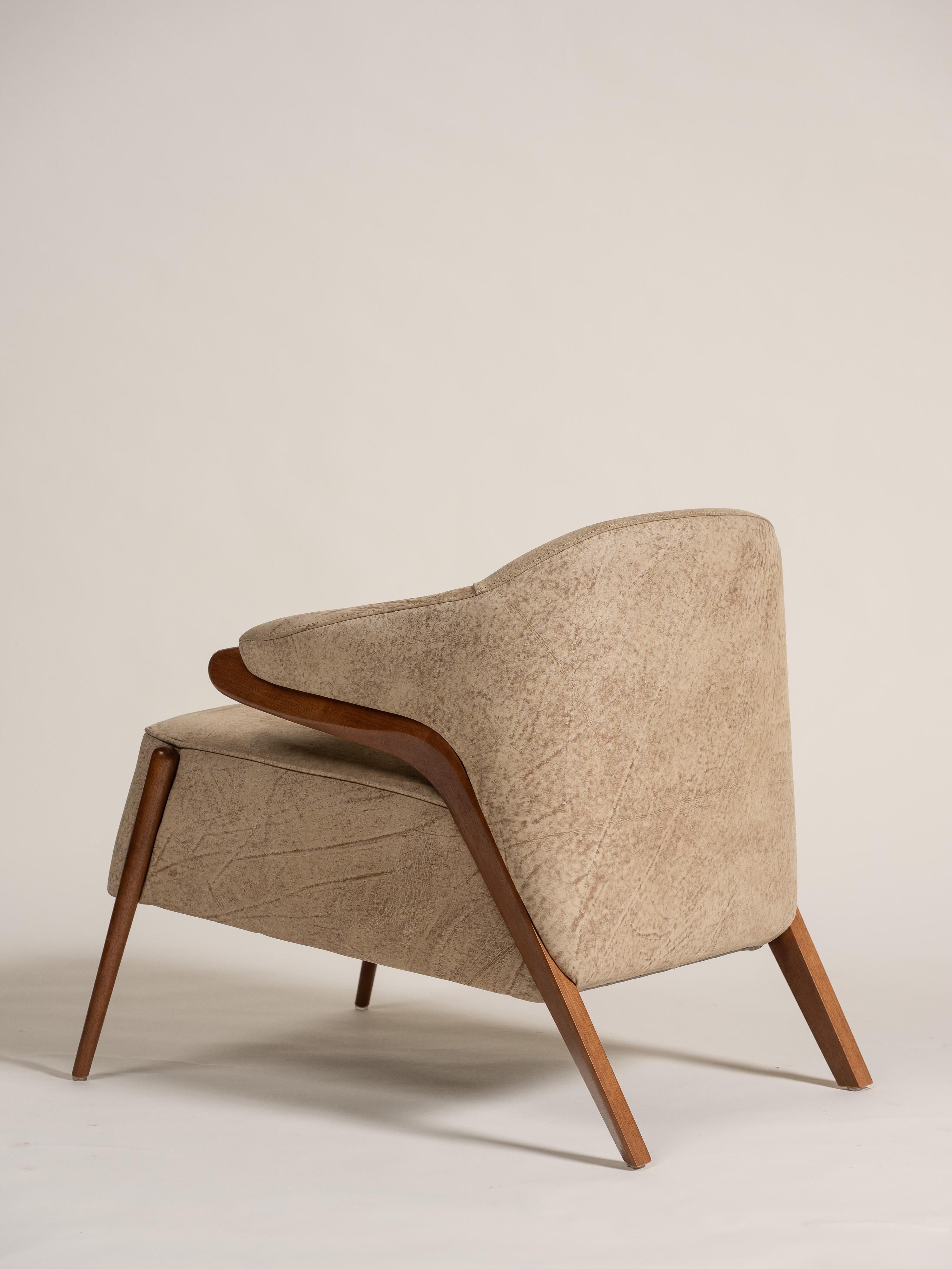 Moderner Sessel Osa mit gebogener Rückenlehne, entworfen von Sérgio Batista für Uultis. Die Kombination aus warmem Walnussholz und braunem Leder in Used-Optik wirkt modern und einladend. Die gepolsterte Sitzfläche, Rückenlehne und Armlehnen sorgen