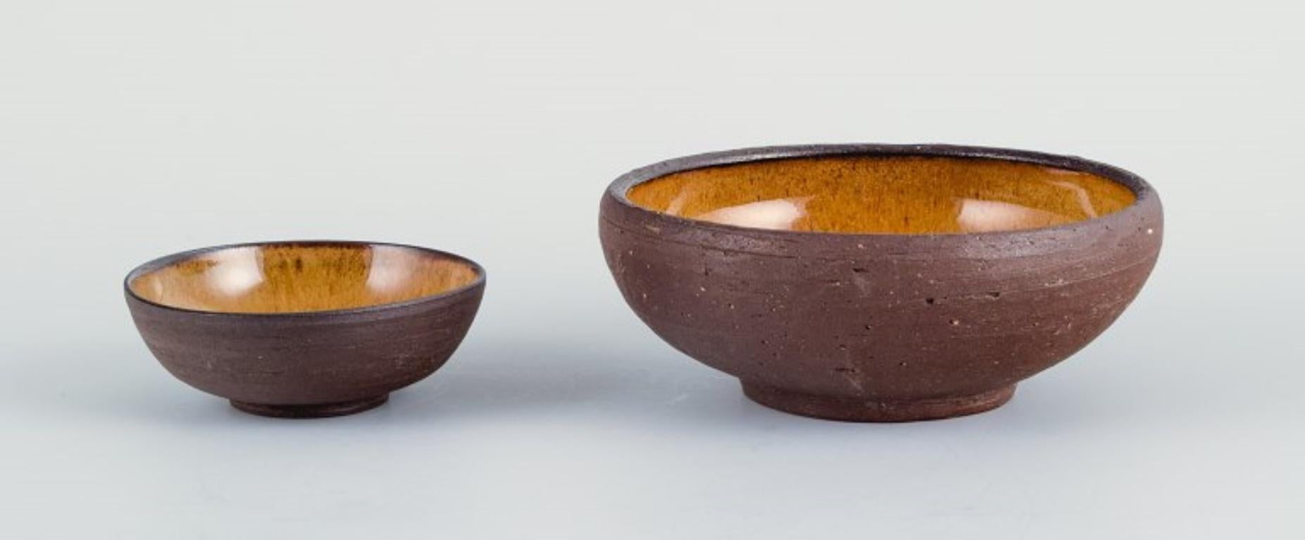 Osa, Denmark.
Two small retro unique ceramic bowls with glaze in yellow-brown tones.
1970s.
In excellent condition.
The large bowl measures: D 12.0 x H 4.5 cm.

OSA was a collaboration between Aase Feilberg, Chr. Frederiksen and Gutte Eriksen.