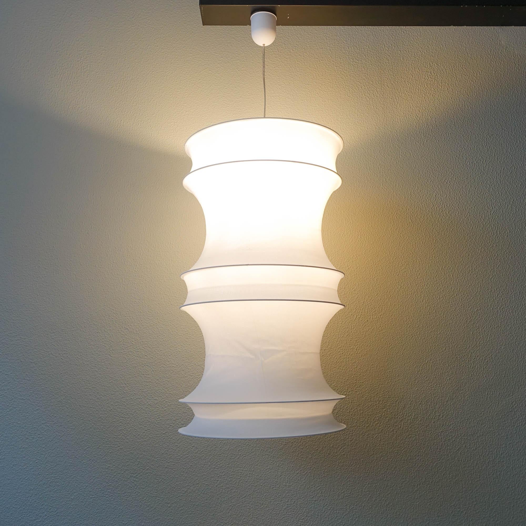This ceiling lamp, model Osaka, was designed and produced by Frandsen Lyskilde between 1993 and 1996, in Denmark. The lamp features a stretchable white fabric were some metal rings are attached to give the organic shape. It can be folded and be a