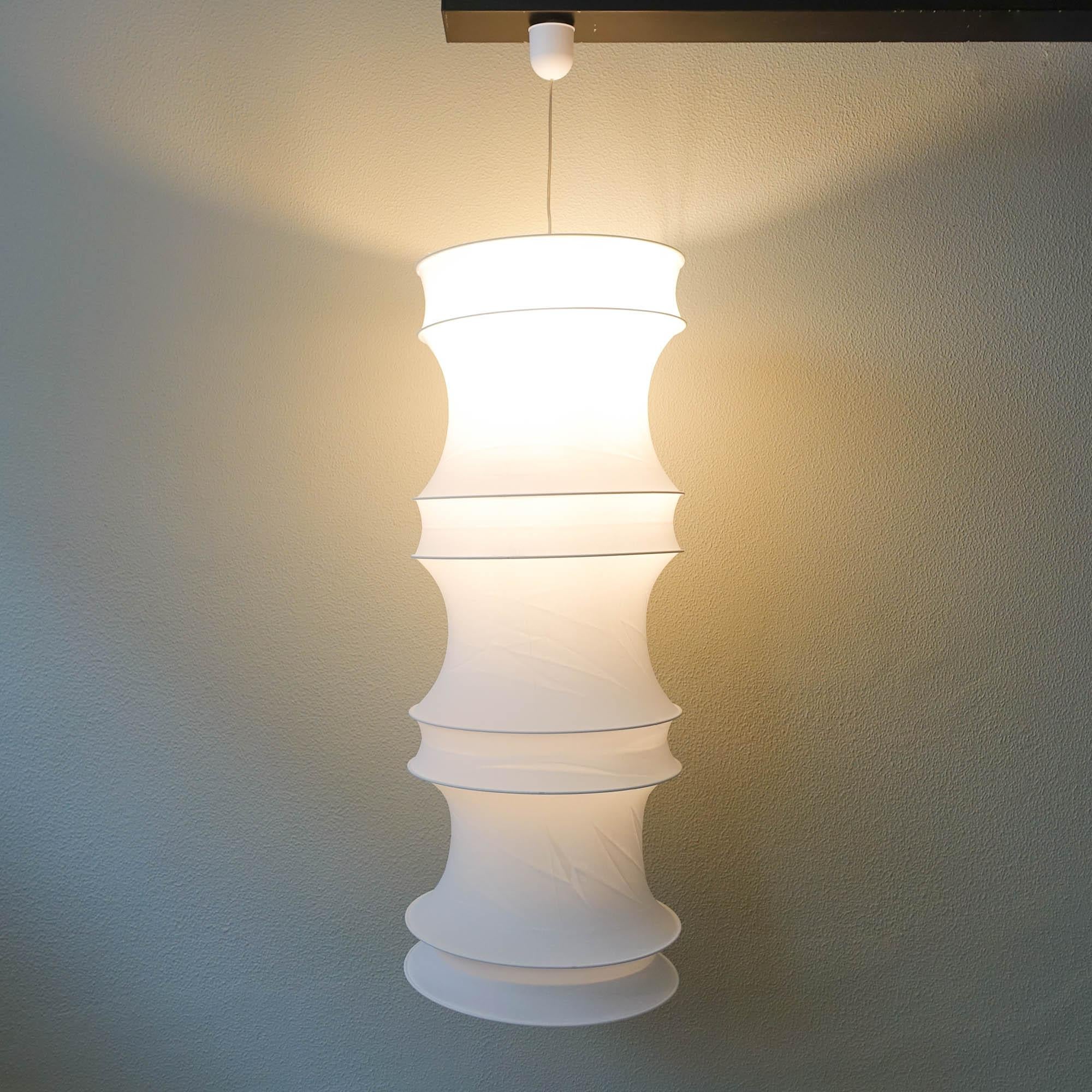 This ceiling lamp, model Osaka, was designed and produced by Frandsen Lyskilde between 1993 and 1996, in Denmark. The lamp features a stretchable white fabric were some metal rings are attached to give the organic shape. It can be folded and be a