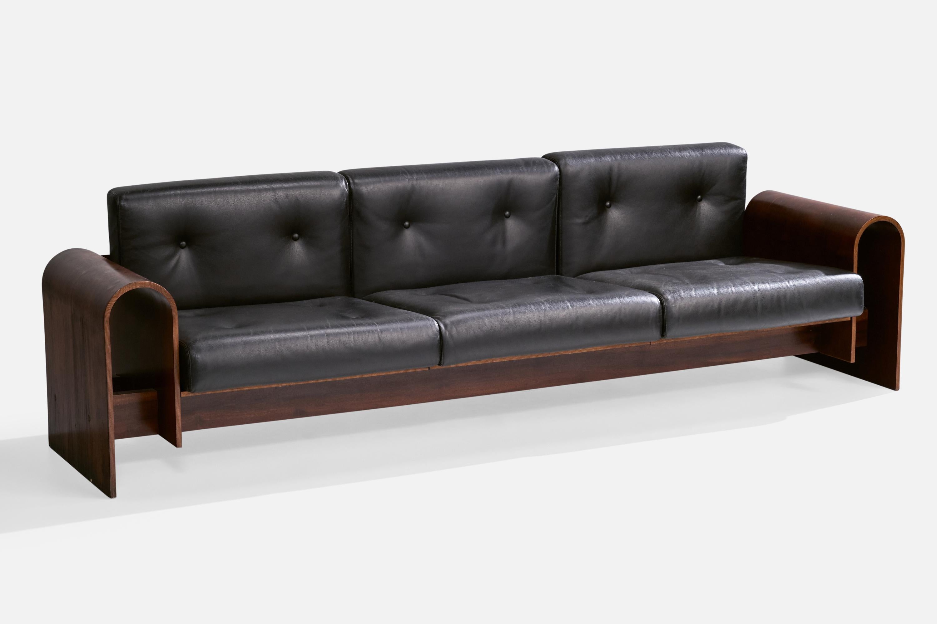An imbuia and leather sofa designed by Oscar and Anna Maria Niemeyer and produced for Hotel SESC, Rio de Janeiro, Brazil, c. 1990.

A few cracks in wood on one of the armrests; minor loss of wood at bottom of side.

Dimensions: 27.5” H x 98” W x