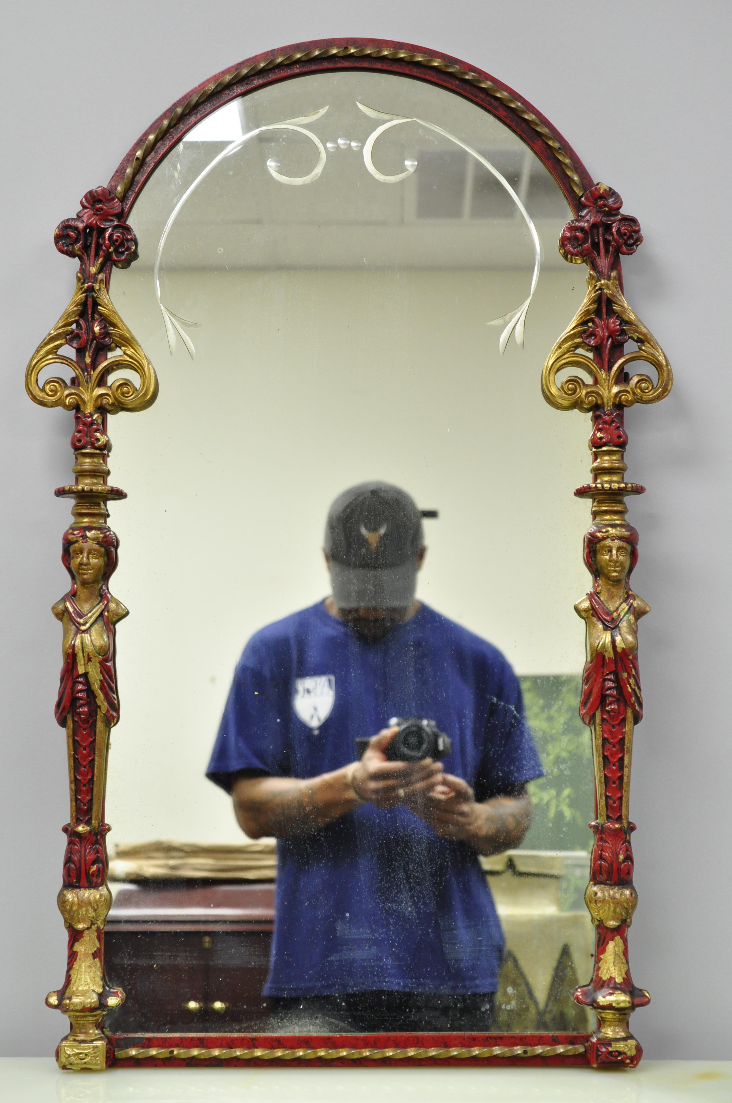 A fine neoclassical motif bronze console table with matching wall mirror attributed to decorative artist Oscar Bach. The table sits on claw feet rising into tapered legs with figural partial nude female busts. The apron is decorated in a red finish