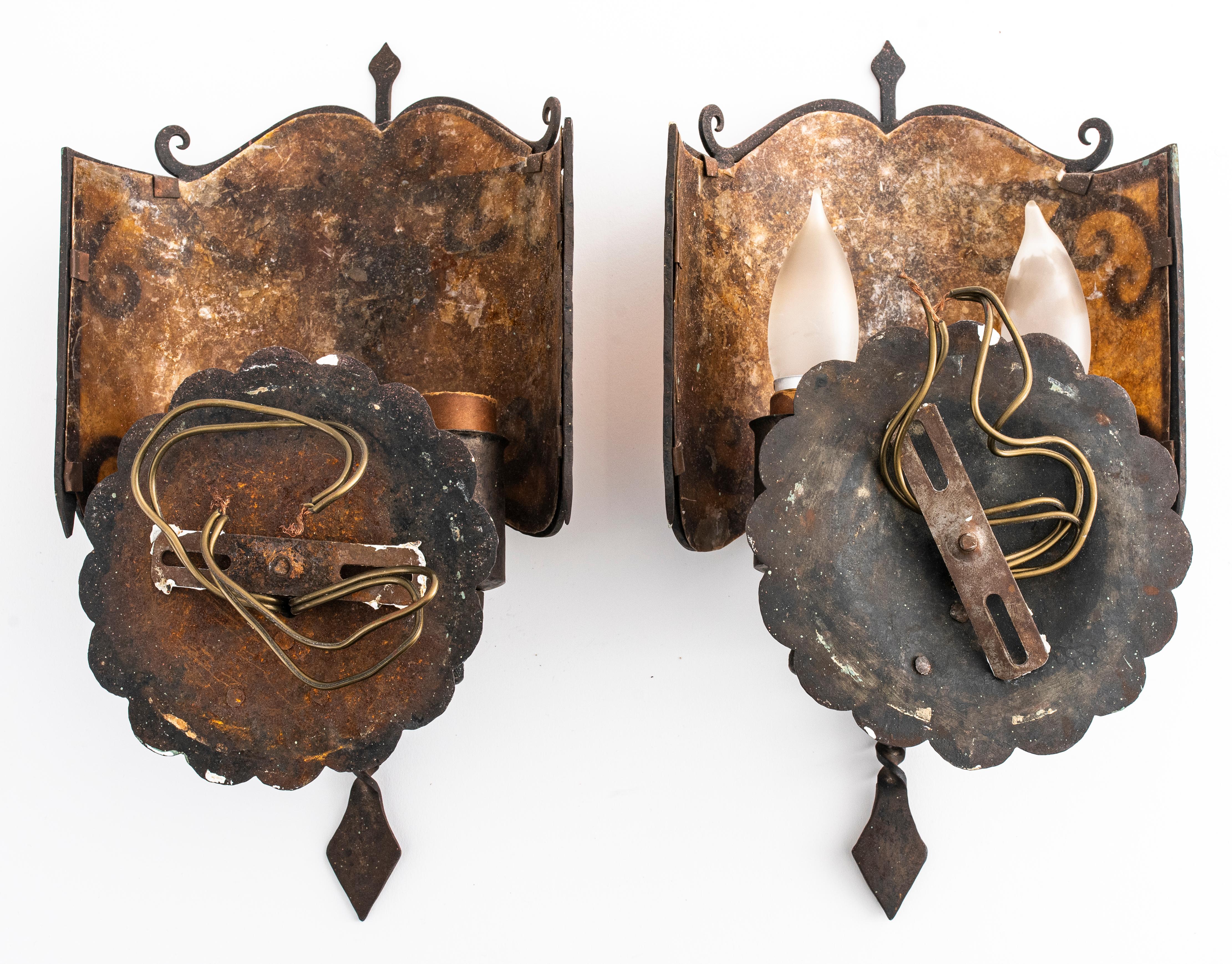 Pair of sconces attributed to Oscar Bach in Arts and Crafts style, with mica shades, hammered metal and decorated with figures of lions. From a Rye, New York private collection. Measures: 13.5
