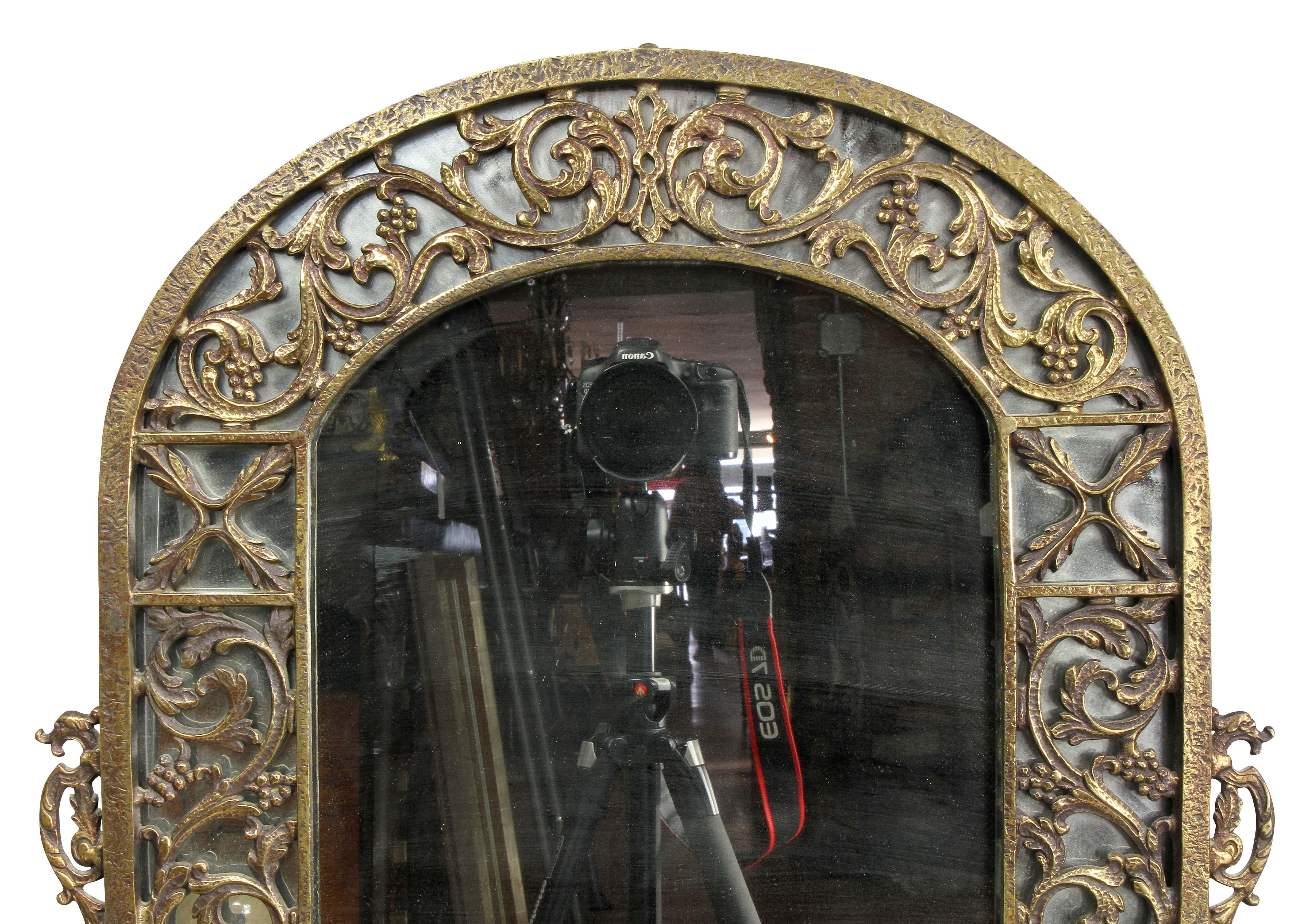 Unsigned with arched top with outer mirror frame with trailing leaf decoration surrounding a conforming mirror plate.