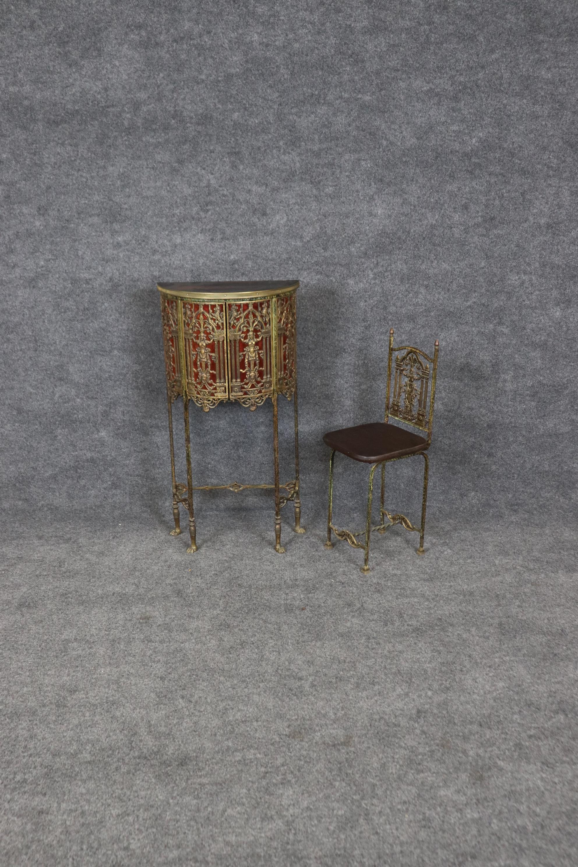 This is a PETITE bronze figural cabinet with incredible workmanship and cast figures and a faux tortoise shell panel behind the front of the grill on the front door. The cabinet can be used for a small desk or vanity. The condition is very good for