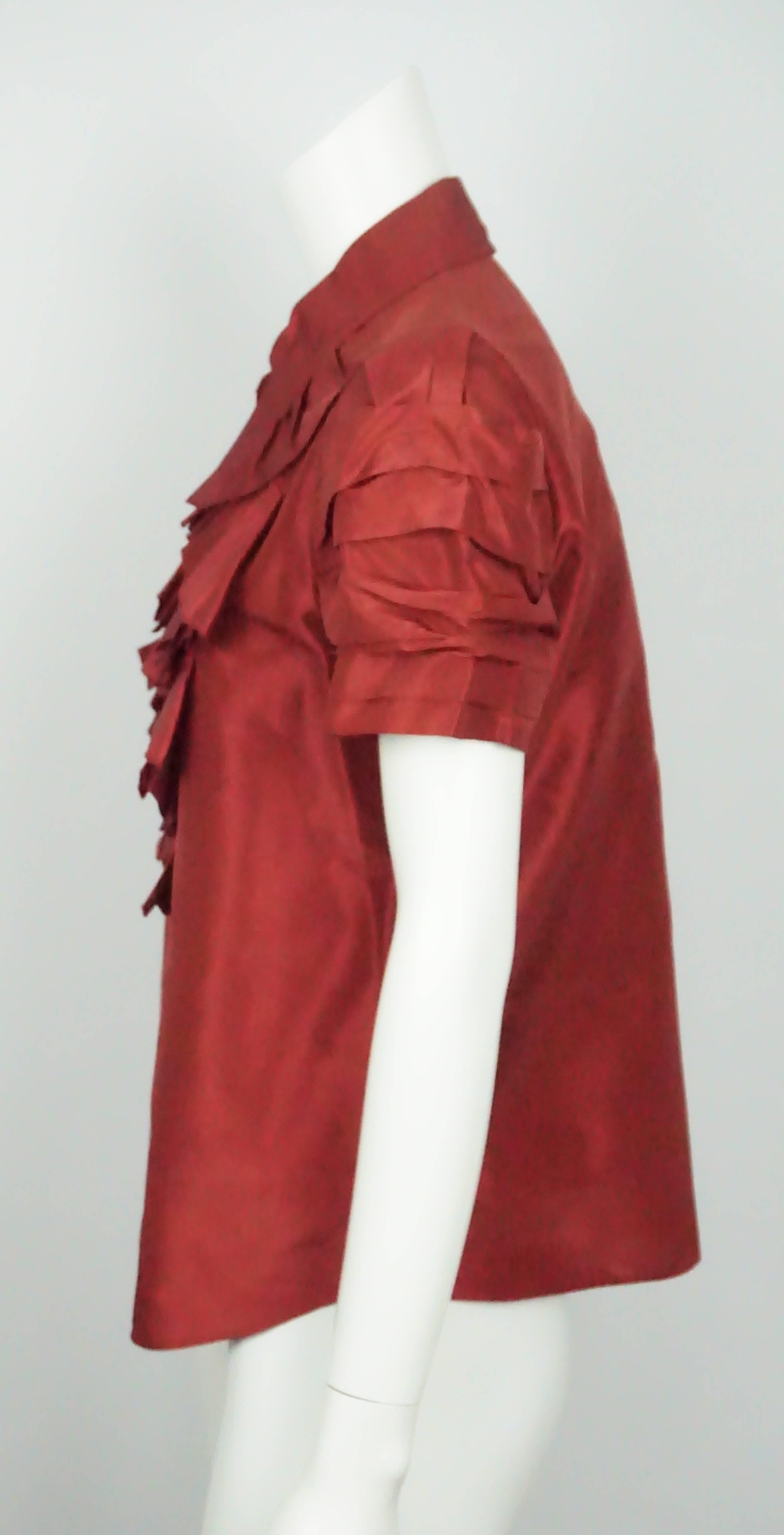Oscar Burgundy Silk Taffeta S/S Ruffled Top-8. This stunning Oscar De La Renta top is in great condition. It is a burgundy/red color and is made of silk. It has short sleeves and ruffle details on the front and sleeves. There are gold and red