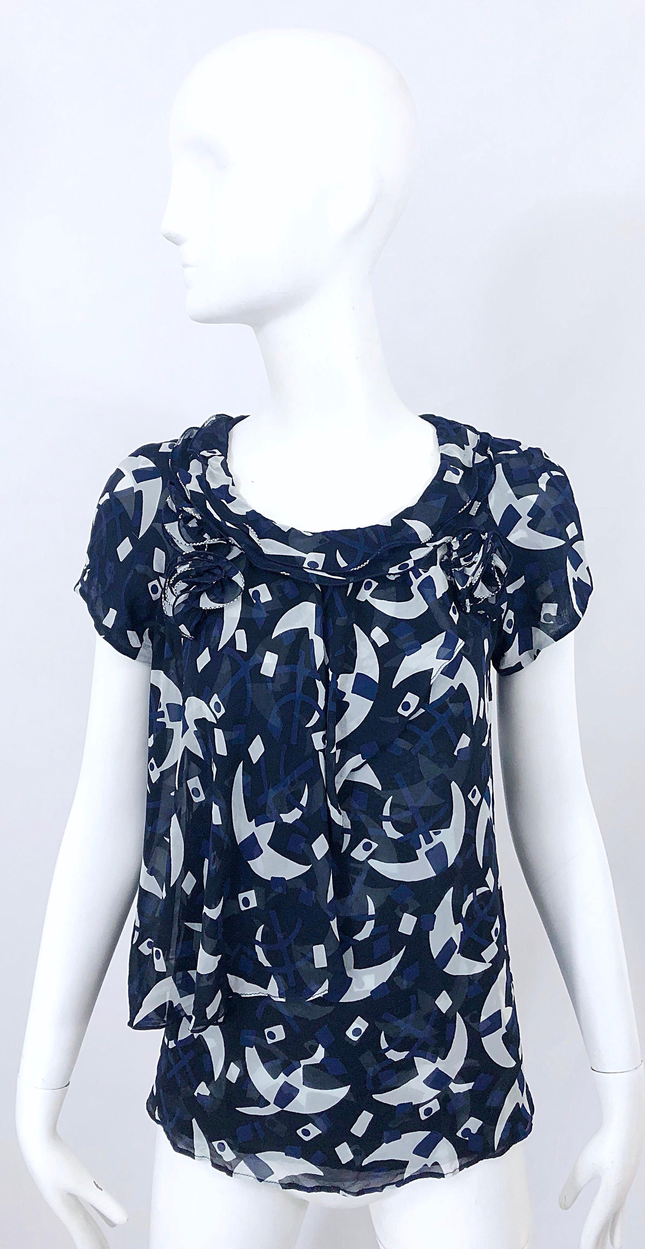 Chic vintage 90s OSCAR DE LA RENTA navy blue, white and black silk chiffon whimsical moon print trapeze blouse! Features a double layered ruffle with rosette appliqués at each side of the shoulder. Forgiving trapeze fit is stylish, comfortable and