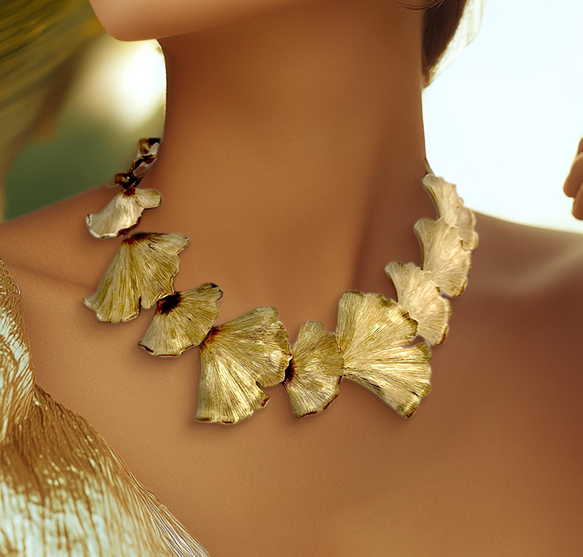 This Oscar de la Renta 22K gold-plated necklace features an intricate composition of interlocking ginkgo leaves hand-cast in pewter and assembled with brass elements. The sculptural statement piece showcases the brand's signature botanical artistry,