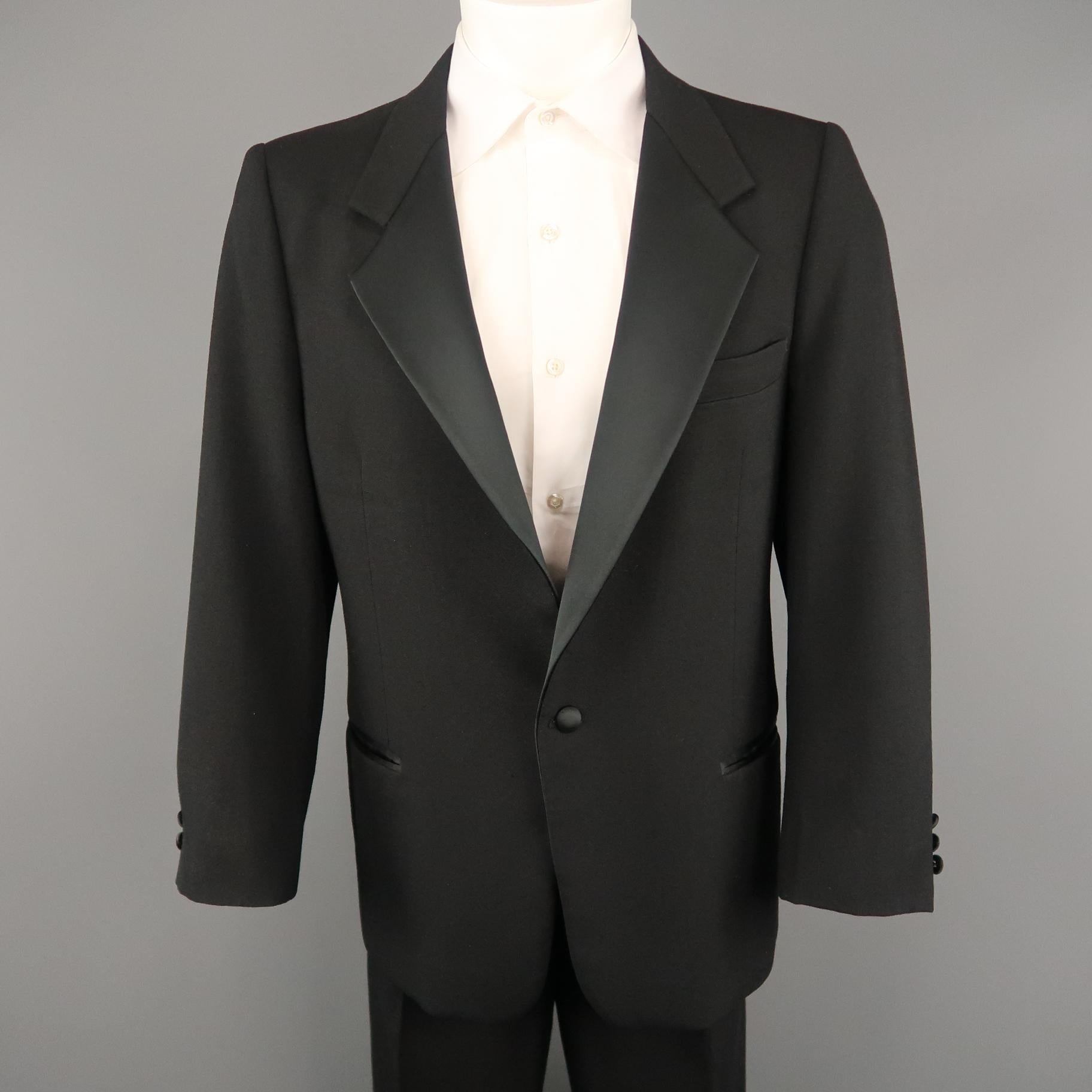 Vintage OSCAR DE LA RENTA men's tuxedo suit comes in black wool and includes a single breasted,  one button sport coat with satin notch lapel and matching pleated ribbon stripe trousers.
 
Excellent Pre-Owned Condition.
Marked: (no size)

