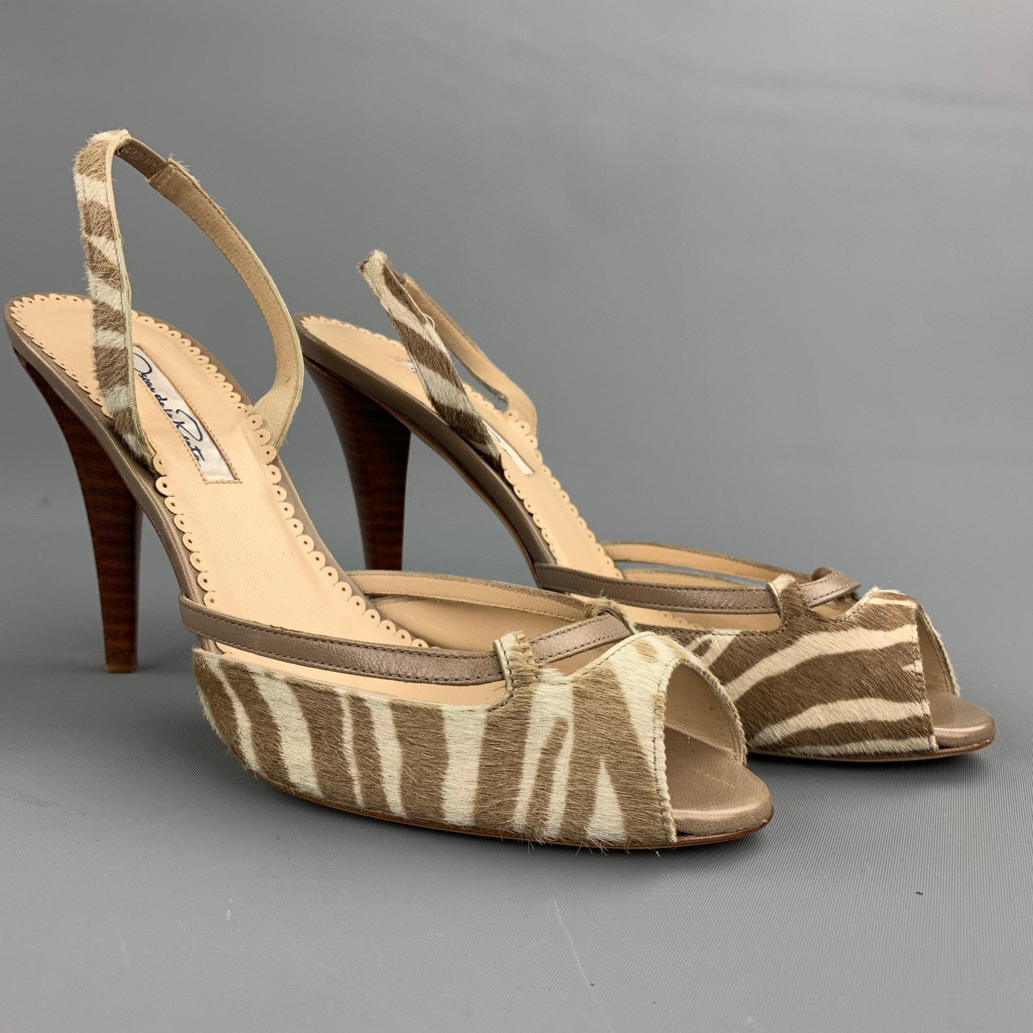 OSCAR DE LA RENTA sandals comes in a off white and taupe tiger zebra print pony hair leather and feature a peep toe with unique cutout details with taupe leather strap, sling back, and a thick neutral brown stacked heel. Faded discoloration on right