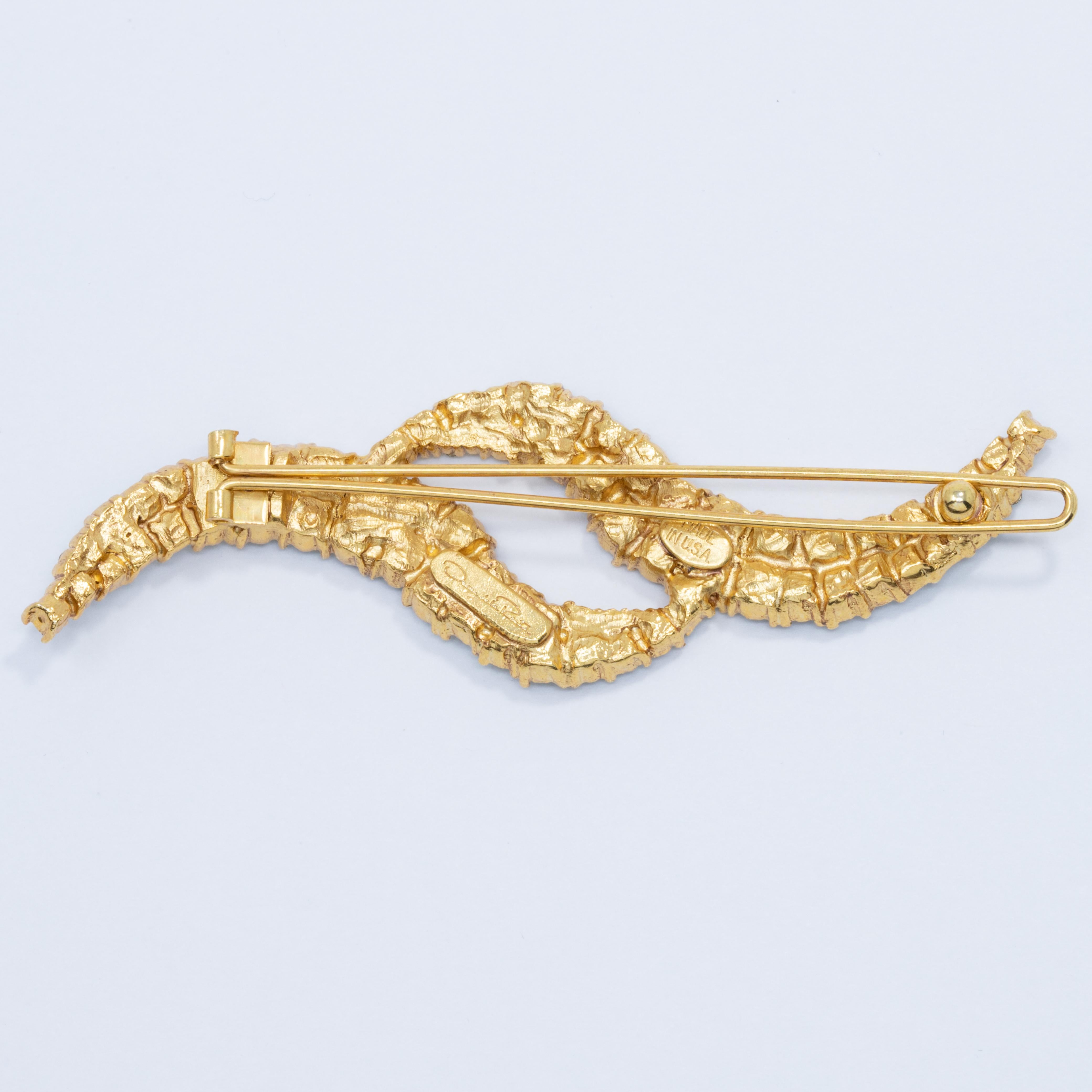 Add some sparkling charm to your wardrobe with this Oscar de la Renta hair clip / brooch. Two flowing, golden wave motifs, decorated with gleaming, aquamarine Swarovski crystals. Sure to catch the eye!

Marks / hallmarks: Oscar de la Renta, Made in