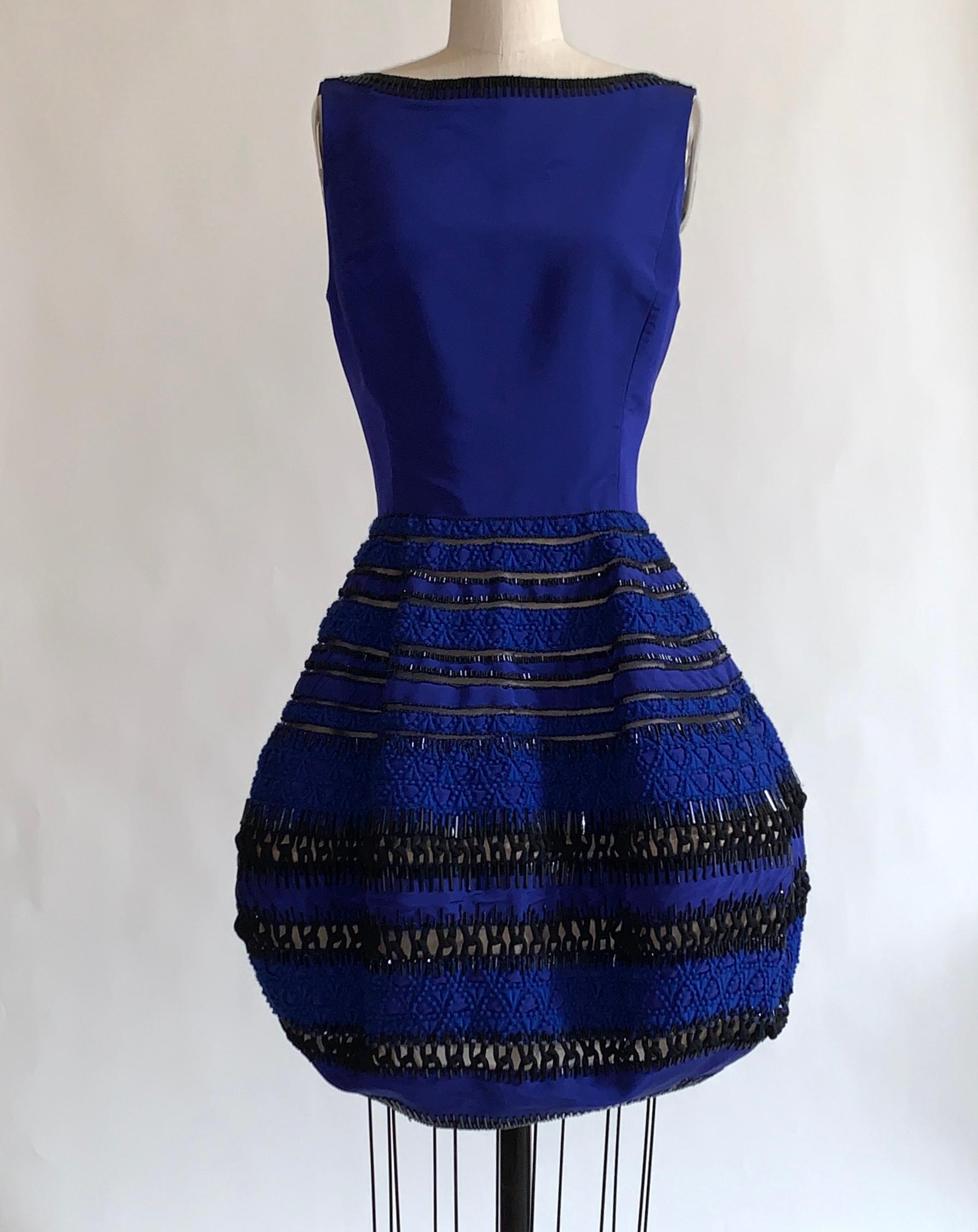 Oscar de la Renta cobalt blue silk dress with embellished skirt. Beading at neckline and throughout skirt. Blue embroidery detail and black ornamental cording at skirt. Back zip. 

100% silk. 
Lined in 100% nylon.

Size US 6, may run small, see