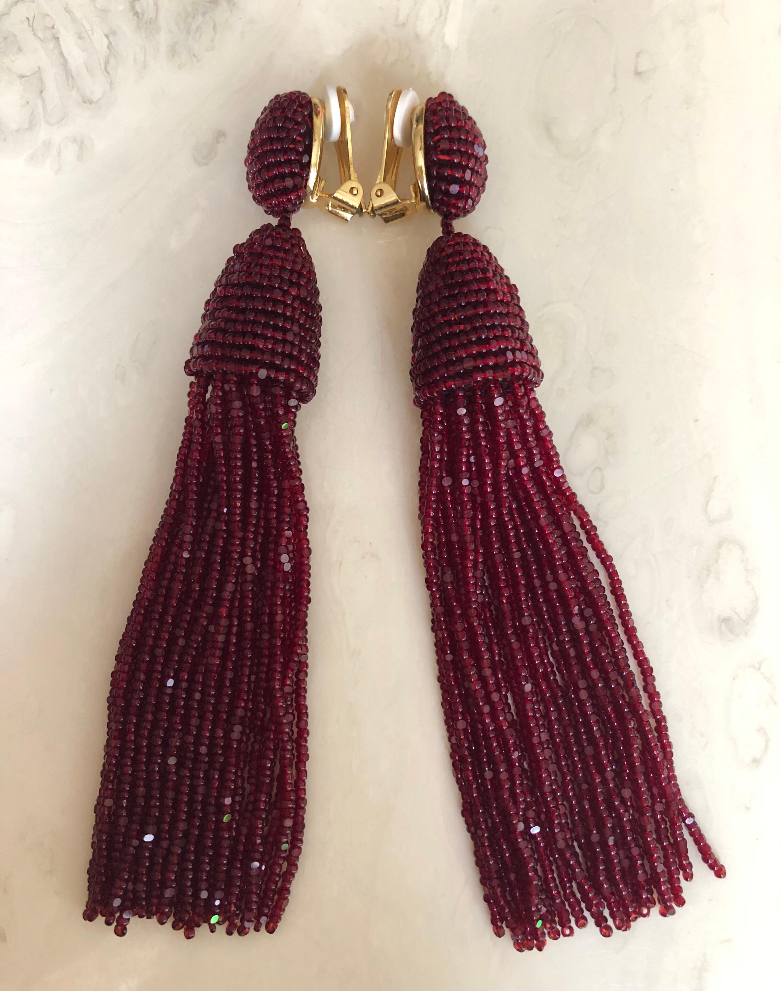 Burgundy seed bead tassel earrings by Oscar de la Renta. 
Gold tone clip on backs with comfort pads  with designer signature on back. 
In excellent condition, looks unworn.

Measurements:
Length: about 5 inches
