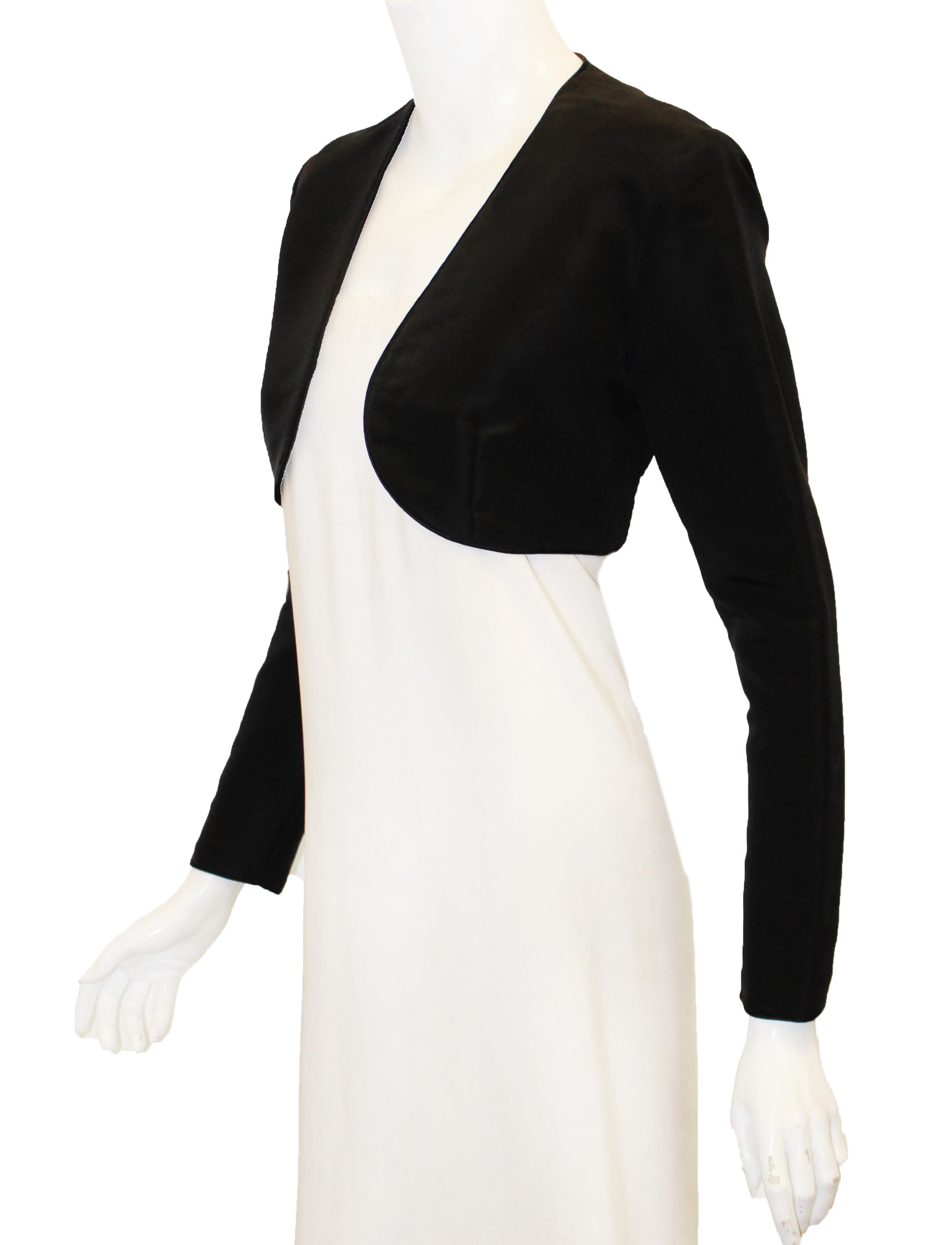 Oscar de la Renta black bolero silk jacket is fully lined in black satin.  This no collar, minimal jacket is practical and easy to wear with a camisole, sleeveless dress or gown as a cover up.  The border is trimmed with rolled cord of same fabric. 