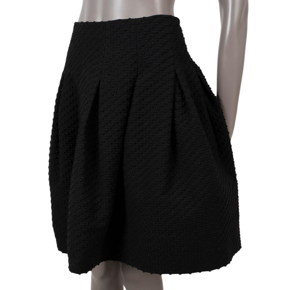 100% authentic Oscar de la Renta flared, pleated nubbed skirt in black acrylic (48%), cotton (28%), viscose (6%) and elastane (1%). Opens with a concealed zipper on the back and is lined in black silk (100%) with tulle band on the bottom for extra