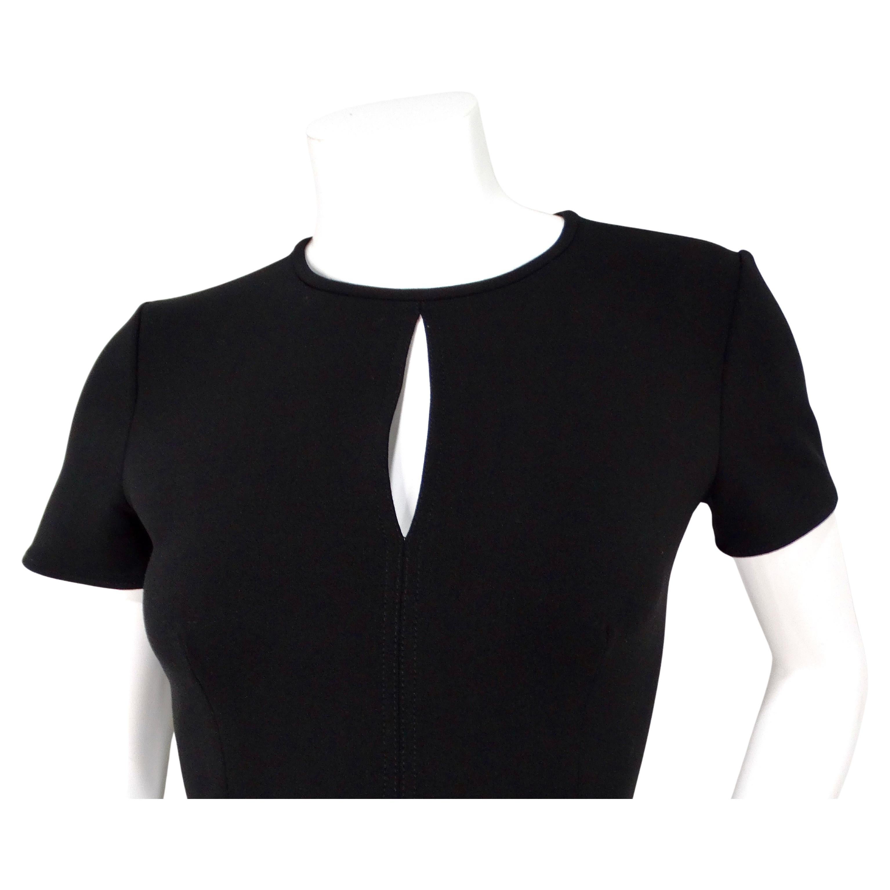 La robe fourreau noire en trou de serrure d'Oscar De La Renta est un superbe exemple d'élégance intemporelle et de design sophistiqué. Cette robe présente une silhouette élégante et moulante qui accentue les courbes naturelles du corps. L'encolure