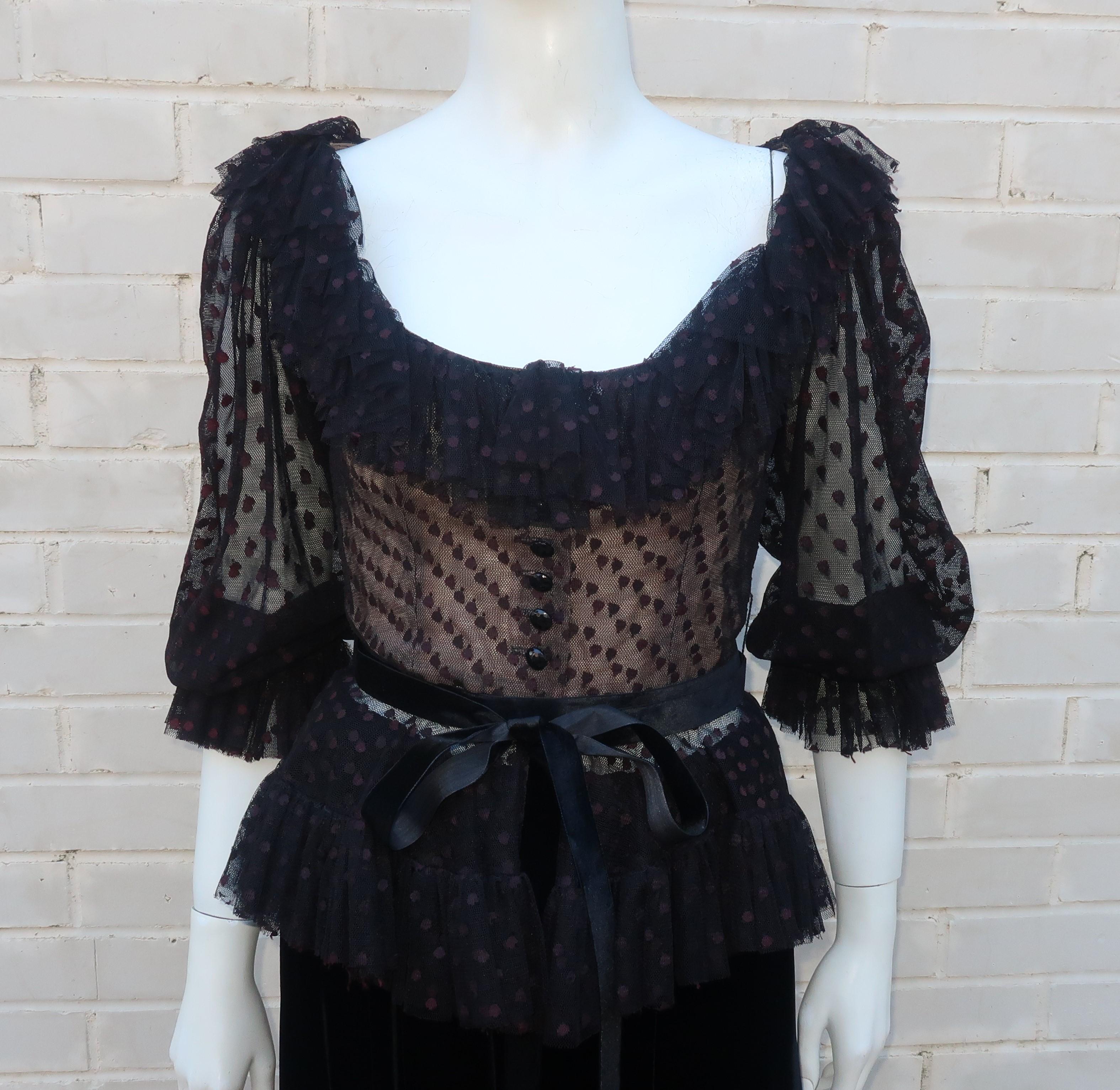 Oscar de La Renta two piece black dress with a dot netted peasant style peplum top and full velvet skirt.  The top buttons down the front with a ruffled collar and full sleeves with elasticized cuffs.  It has a nude illusion modesty lining and