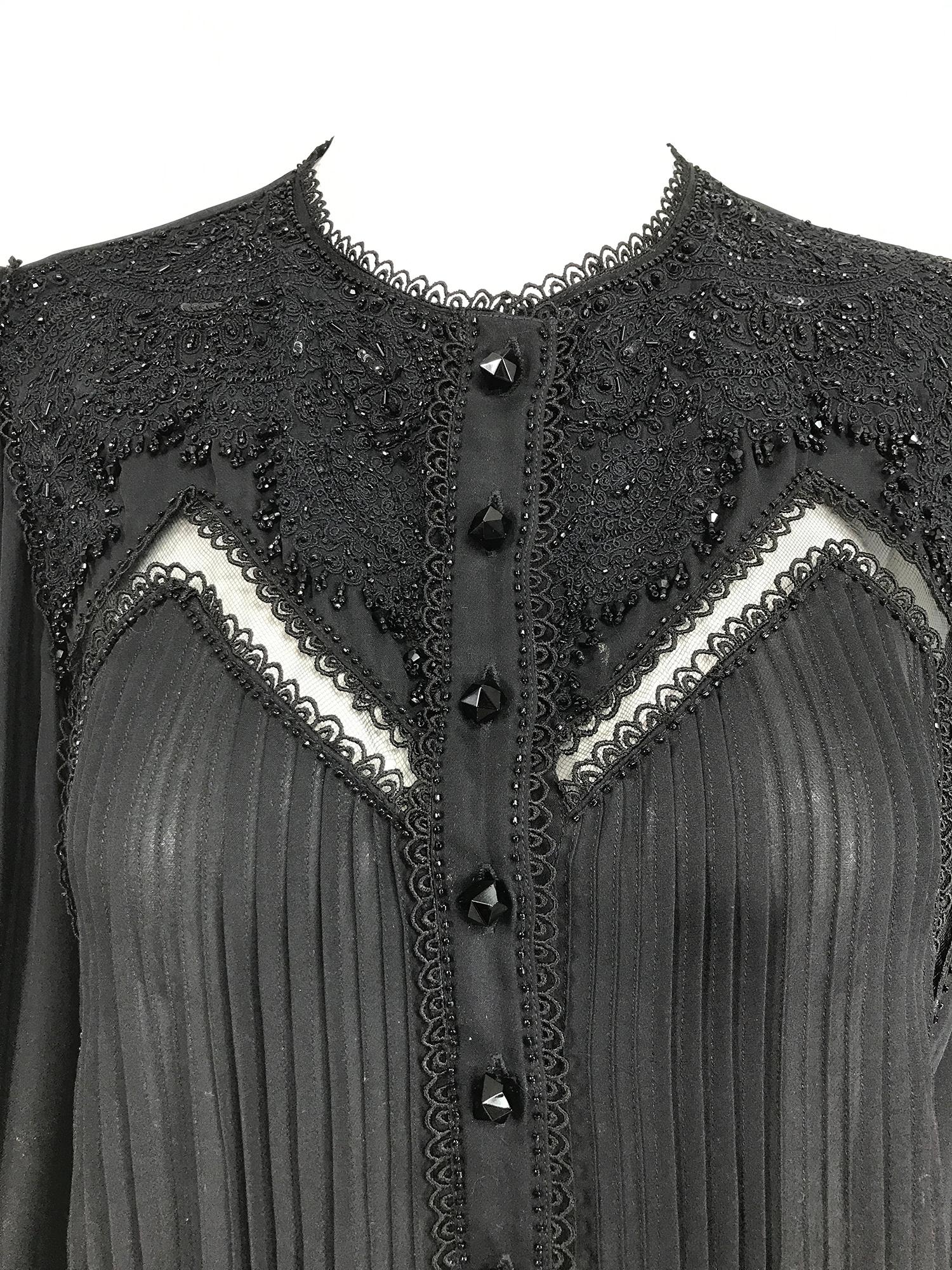 Oscar de la Renta black Beaded Chiffon Poet Sleeve Blouse. Gorgeous blouse with lace edge jewel neckline, long full sleeves with ruffle lace edge cuff and elastic wrist.
The blouse closes at the front with faceted shaped black glass buttons, the