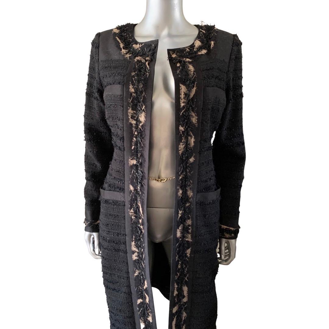 A super chic American design legend version of a Chanel Cardigan Coat. The quality of this coat is amazing. Firstly, the black bouclé is imported and has a metallic thread to it. Then the trim os a shredded black fringe mixed with a shredded tan and