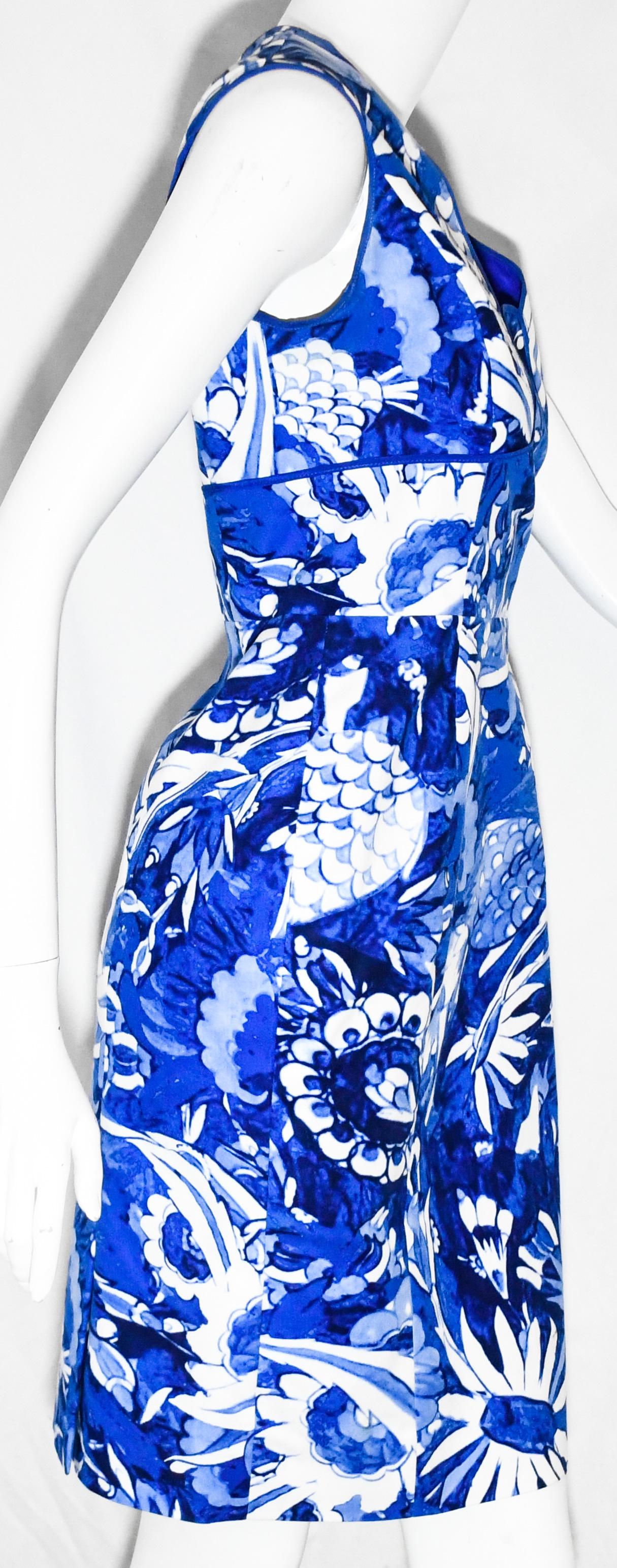 Oscar de la Renta white and blue  structured dress is printed with a traditional blue and white floral pattern that has been perfectly disjointed through slim vertical blue trim on the bodice.  This V neck dress is highlighted with the ever present