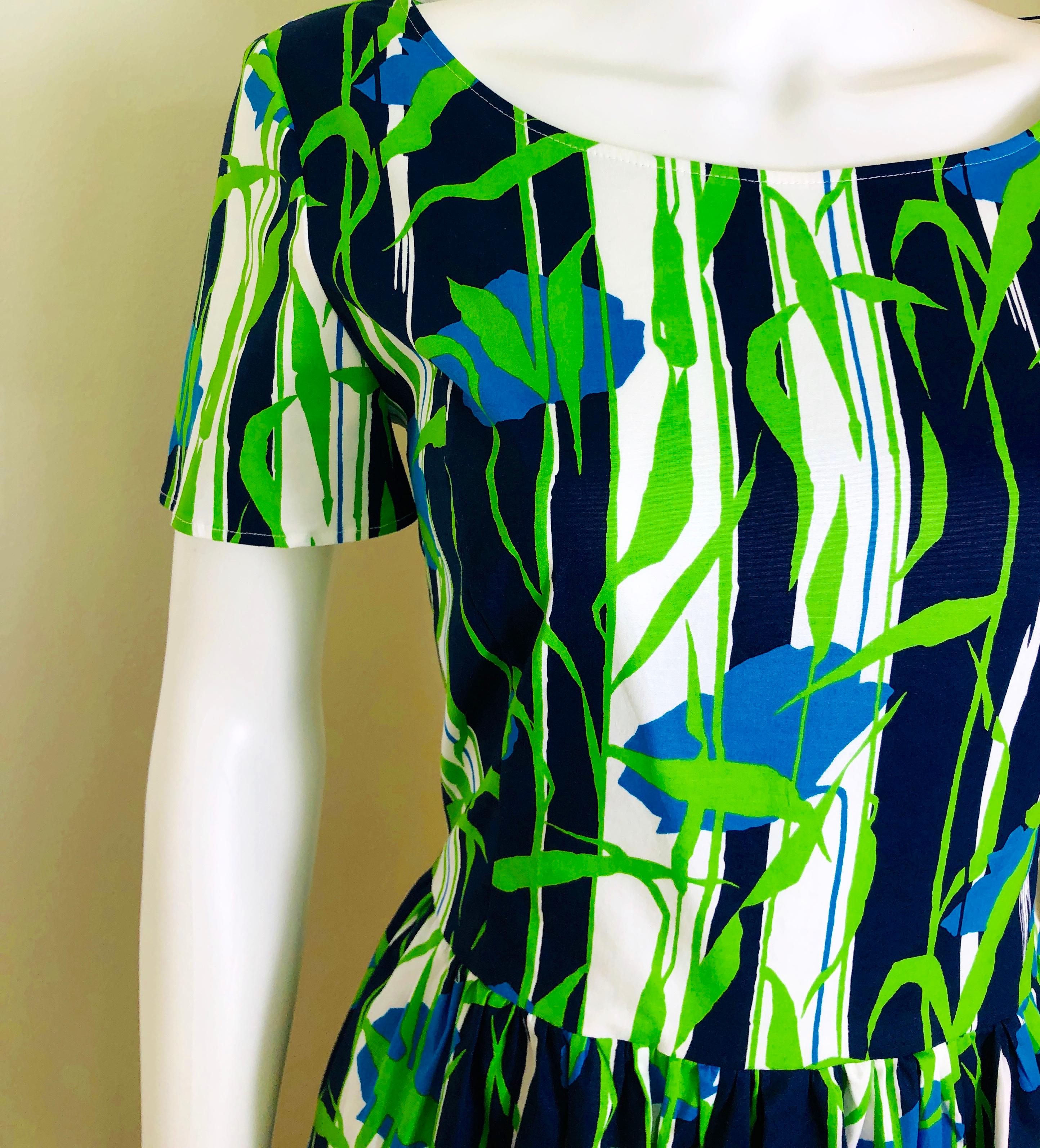 Offered is a signed size 6, made in Italy, Oscar de la Renta blue, green and white floral pattern short sleeve flare and fitted cotton percale day dress.  The bodice of the dress to the waist is quite fitted and then flares out from the waist,