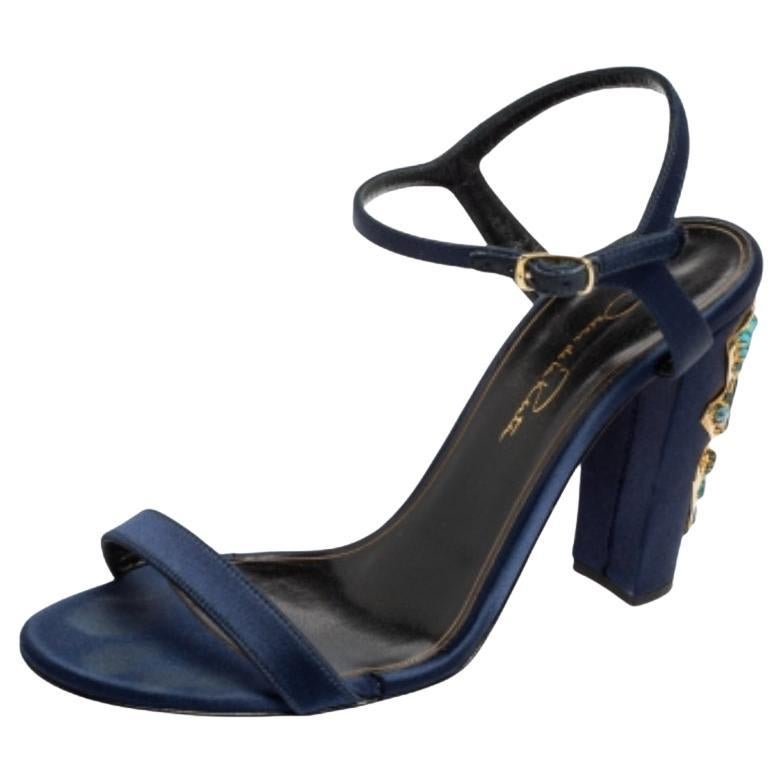 Il fascino e il glamour di questi sandali Oscar De La Renta ti faranno sicuramente battere il cuore. Sono realizzate in raso con una silhouette open-toe. Questo elegante paio è dotato di cinturini alla caviglia, solette foderate in pelle e tacchi a