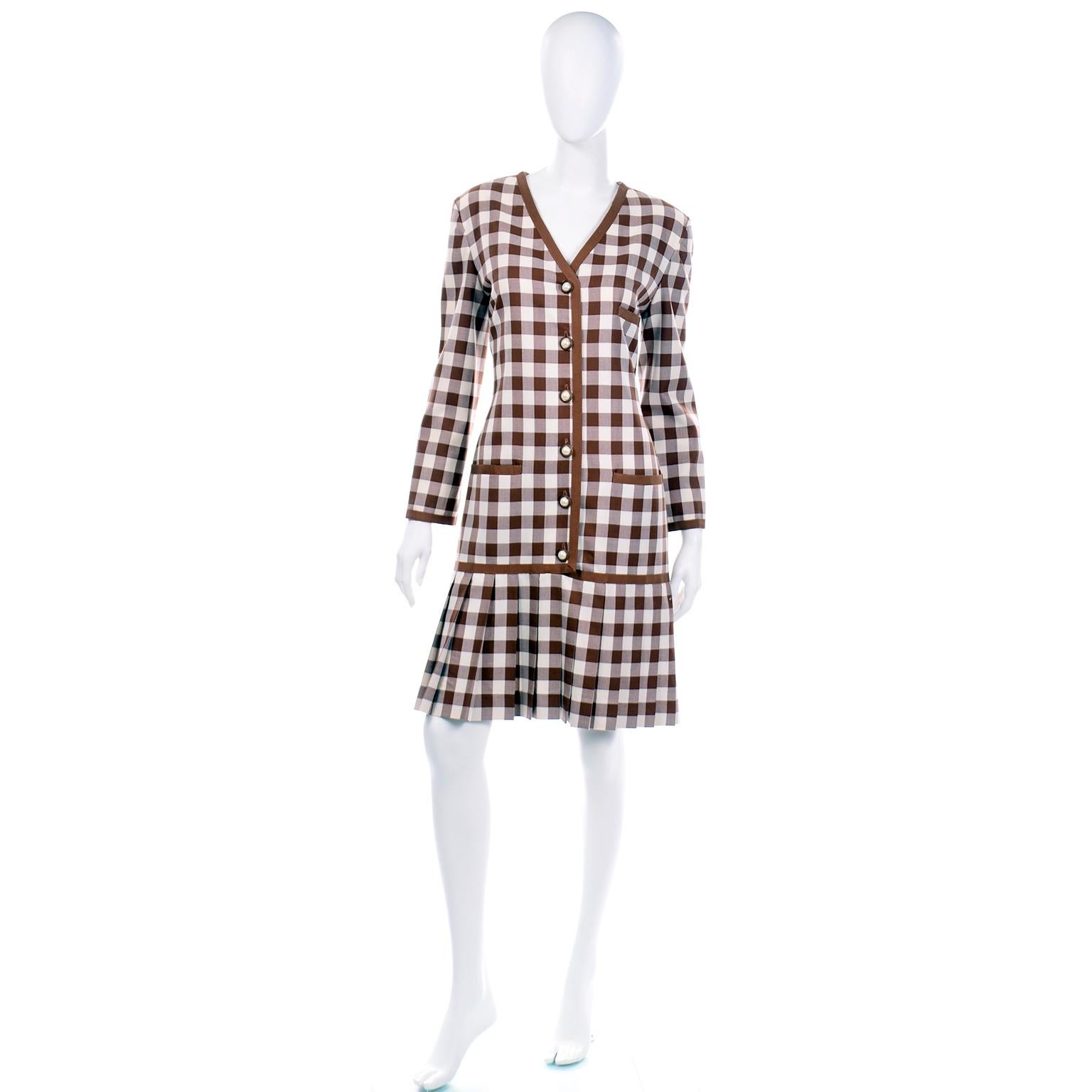 This is a a really fun deadstock Oscar de la Renta dress. This brown and white check dress has a v-neck with pearl buttons down the center front for opening and a fun pleated hem. There are two functional slit pockets and single breast slit pocket