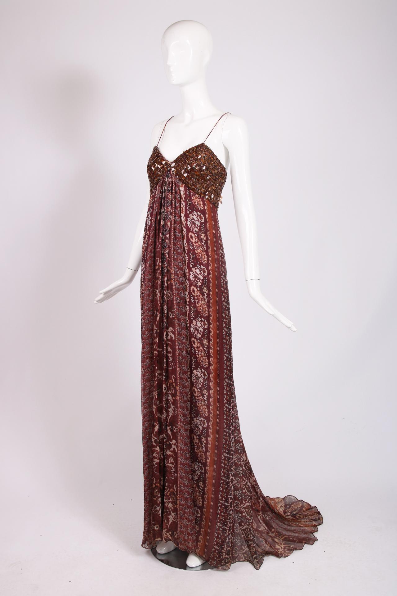 Late 1990's Oscar de la Renta strapless evening gown featuring spaghetti straps, a beaded and embroidered bodice and a skirt comprised of multiple layers of a foliate printed chiffon in a palette of burgundy, rust and brown. There is a small train