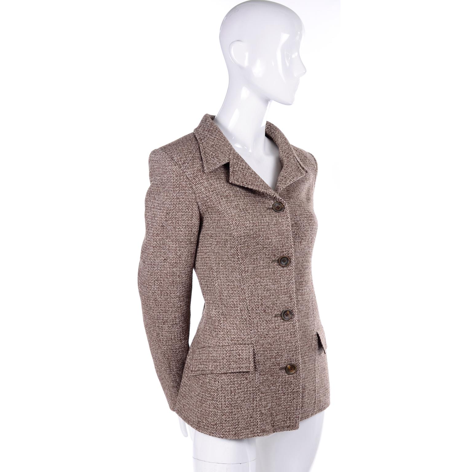 This is a great Oscar de la Renta four button blazer in a lovely brown tweed. This jacket has a notched collar and two flap pockets in front that are still sewn shut! What is unique about this jacket is the back. It has three large pleats at the