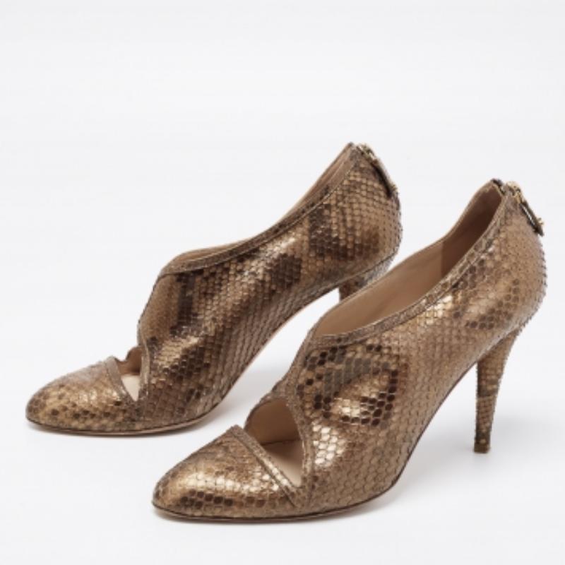 Estos botines Oscar De La Renta de bonito diseño enmarcarán tus pies con lujo. Confeccionados en piel de pitón, tienen cierre de cremallera en los contrafuertes, herrajes dorados y tacón de 11 cm. Los cortes precisos de este par le añaden un toque