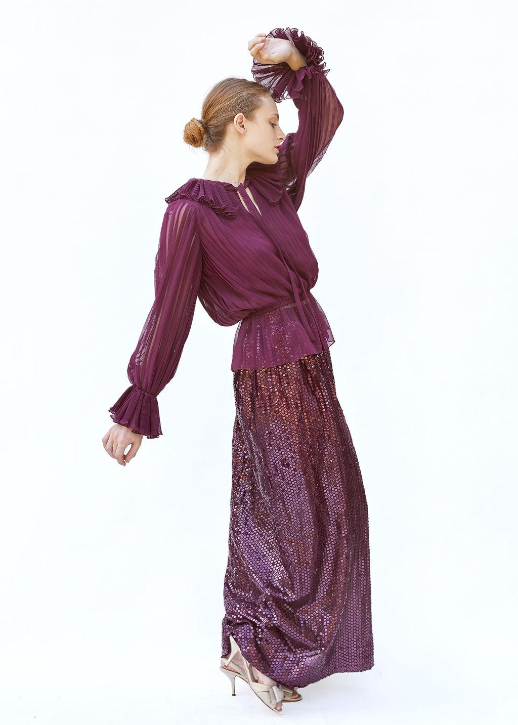 Step into sophistication with this Oscar De La Renta ensemble, featuring a burgundy sequin skirt and a delicately pleated top that radiates timeless elegance. The high-waisted sequin skirt dazzles with rich burgundy sequins, creating a mesmerizing