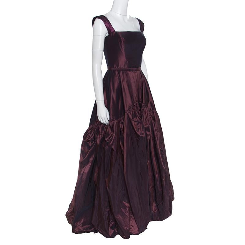 We've fallen in love and so will you with this magnificent gown from Oscar de la Renta! This burgundy sleeveless gown is made of 100% silk and features a tiered silhouette. It flaunts a rectangular neckline, a belt detailing on the waist and a