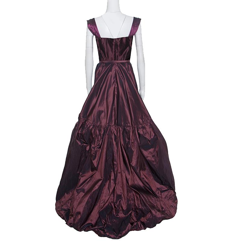 We've fallen in love and so will you with this magnificent gown from Oscar de la Renta! This burgundy sleeveless gown is made of 100% silk and features a tiered silhouette. It flaunts a rectangular neckline, a belt detailing on the waist and a