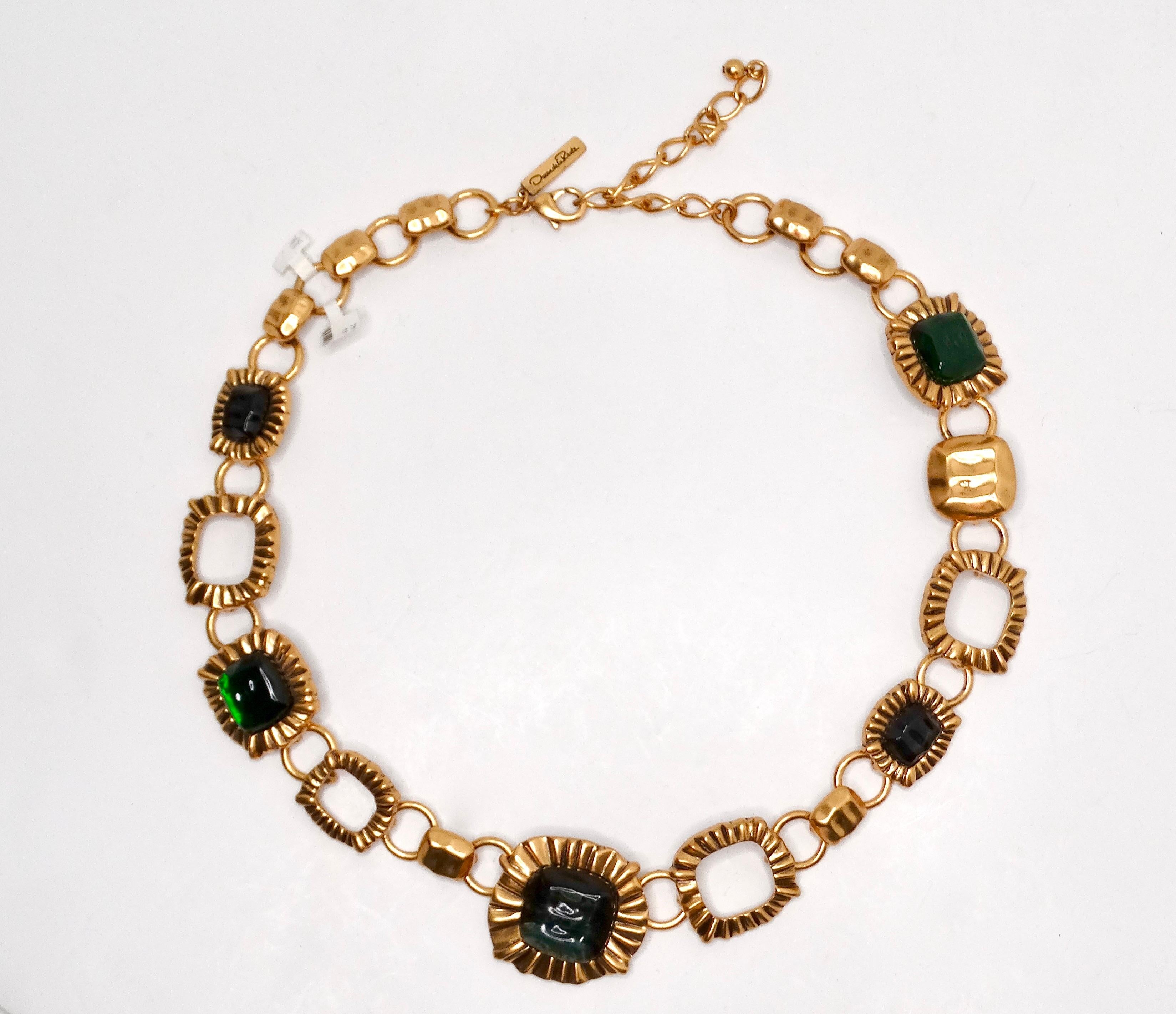 El Collar de cadena verde en forma de joya Oscar De La Renta Circa 1990s es un accesorio vibrante y llamativo que encarna la audacia de la época. Esta asombrosa pieza presenta un conjunto de ricos elementos verdes y dorados, elaborados con maestría