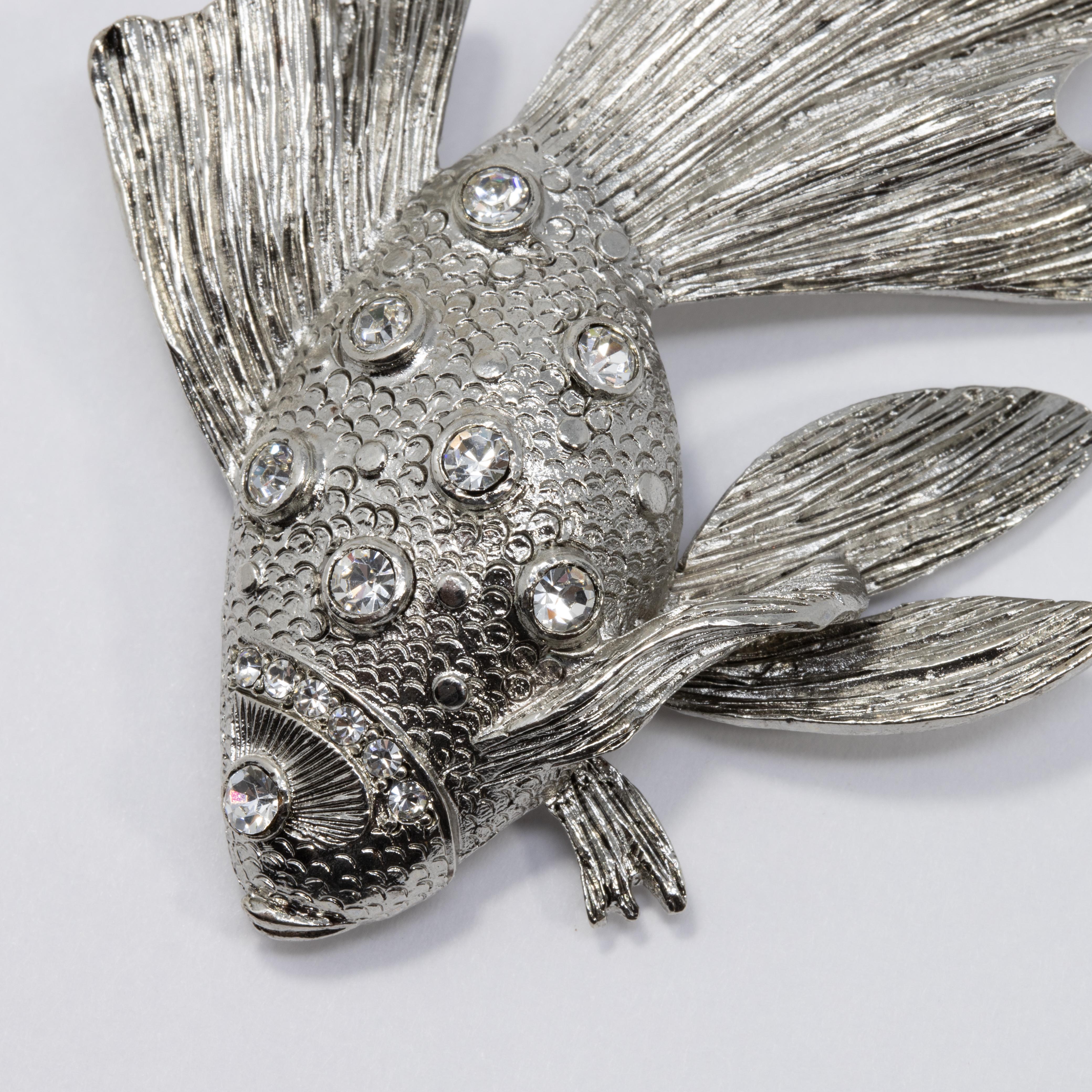 Perfect your look with this silver-tone fish brooch set with sparkling Swarovski crystals. For the perfect marine aesthetic!

Hallmarks: Oscar de la Renta, Made in USA