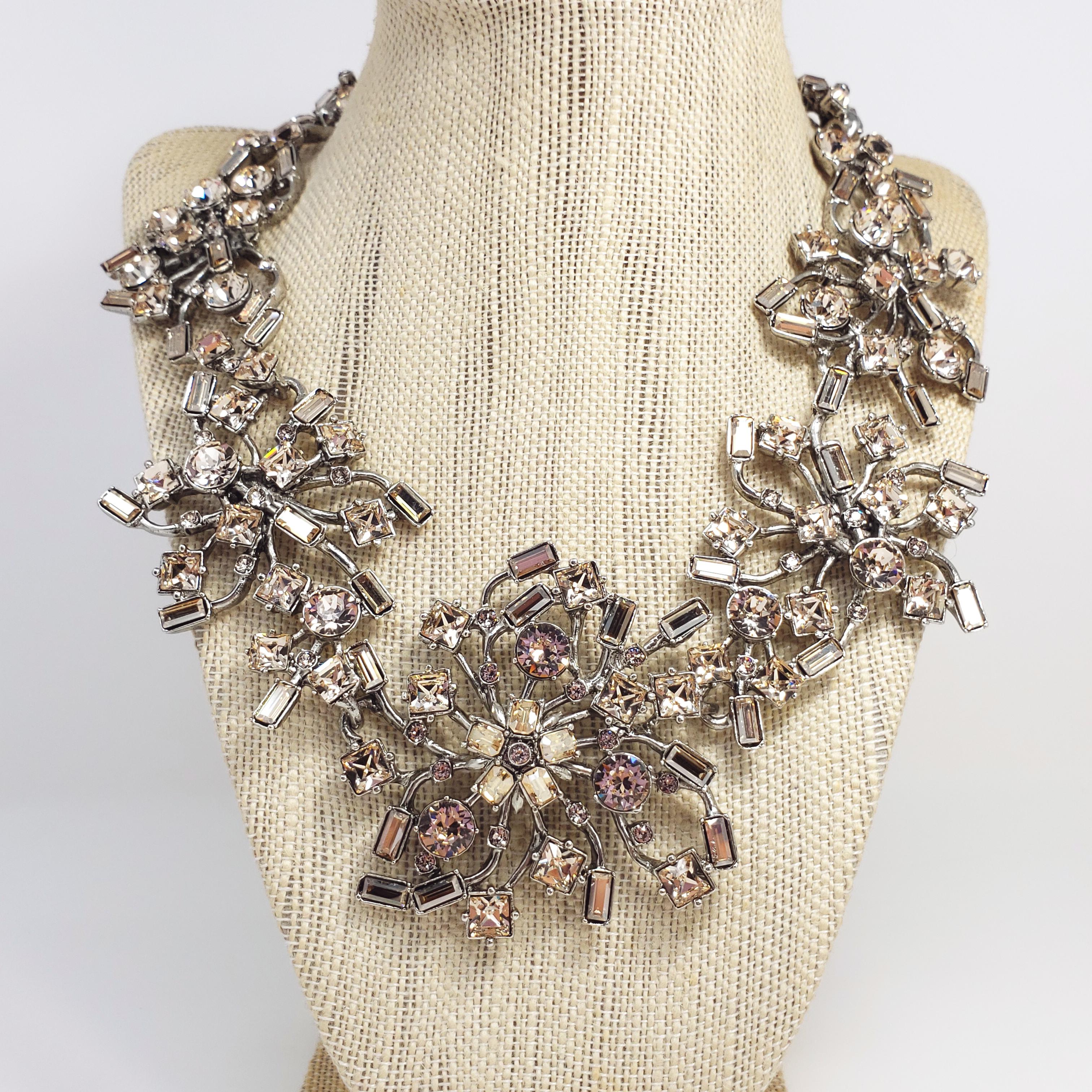 A dazzling necklace by Oscar de la Renta. Features translucent, smoky topaz crystals in round, square, and emerald cuts. Prong set on contemporary-styled floral motif silvertone setting. Lavish!

Hallmarks: Oscar de la Renta, Made in USA
Largest