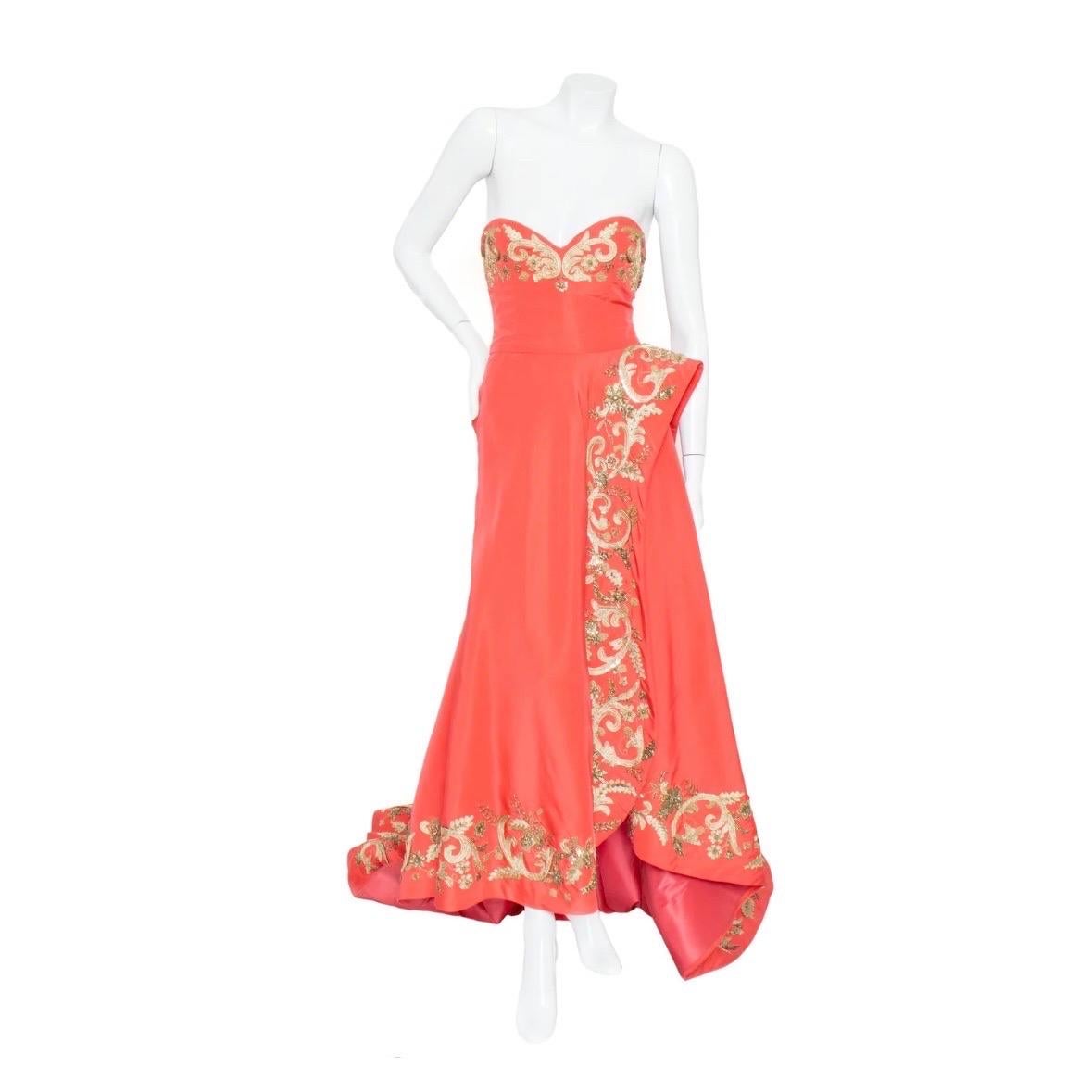 Vestido coral bordado de Oscar De La Renta
Colección Pre-Fall 2014
Sin tirantes 
Escote corazón
Florituras bordadas en oro
Detalles con cuentas
Detalle lateral esculpido
Corpiño interior deshuesado
Cierre trasero con cremallera
Tren largo
Bajo alto,