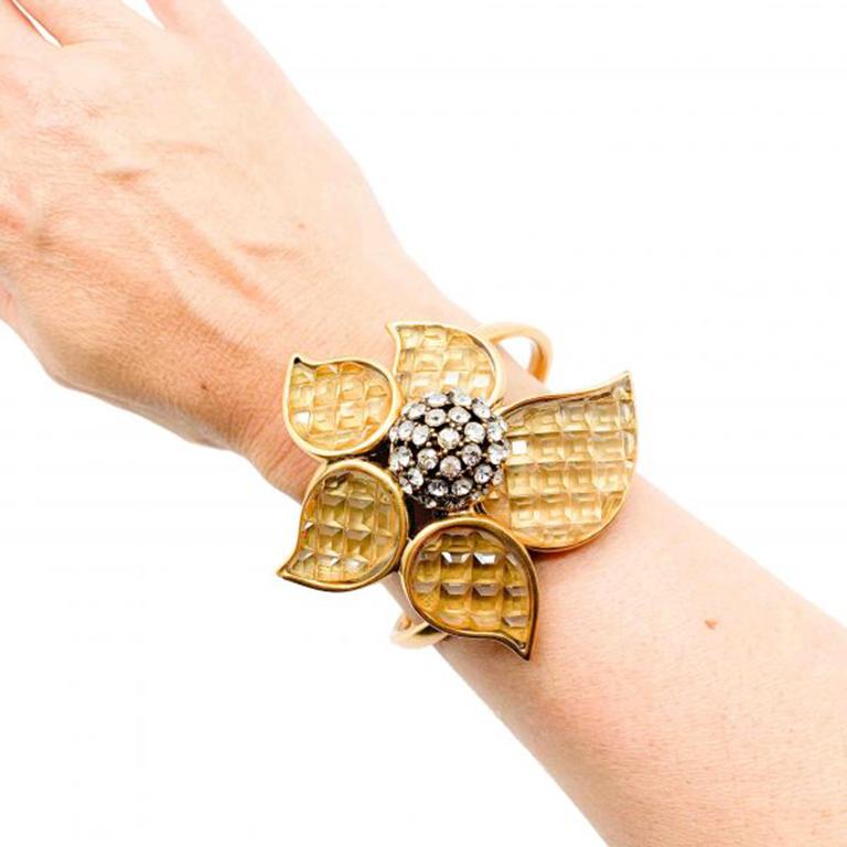 A fabulous Oscar de la Renta Cuff. The faux 'invisible setting' giving the look of invisibly set citrines. A beautifully decorated stylised flower formation with a crystal ball centre for the finishing touch. In gold plated metal with glass and