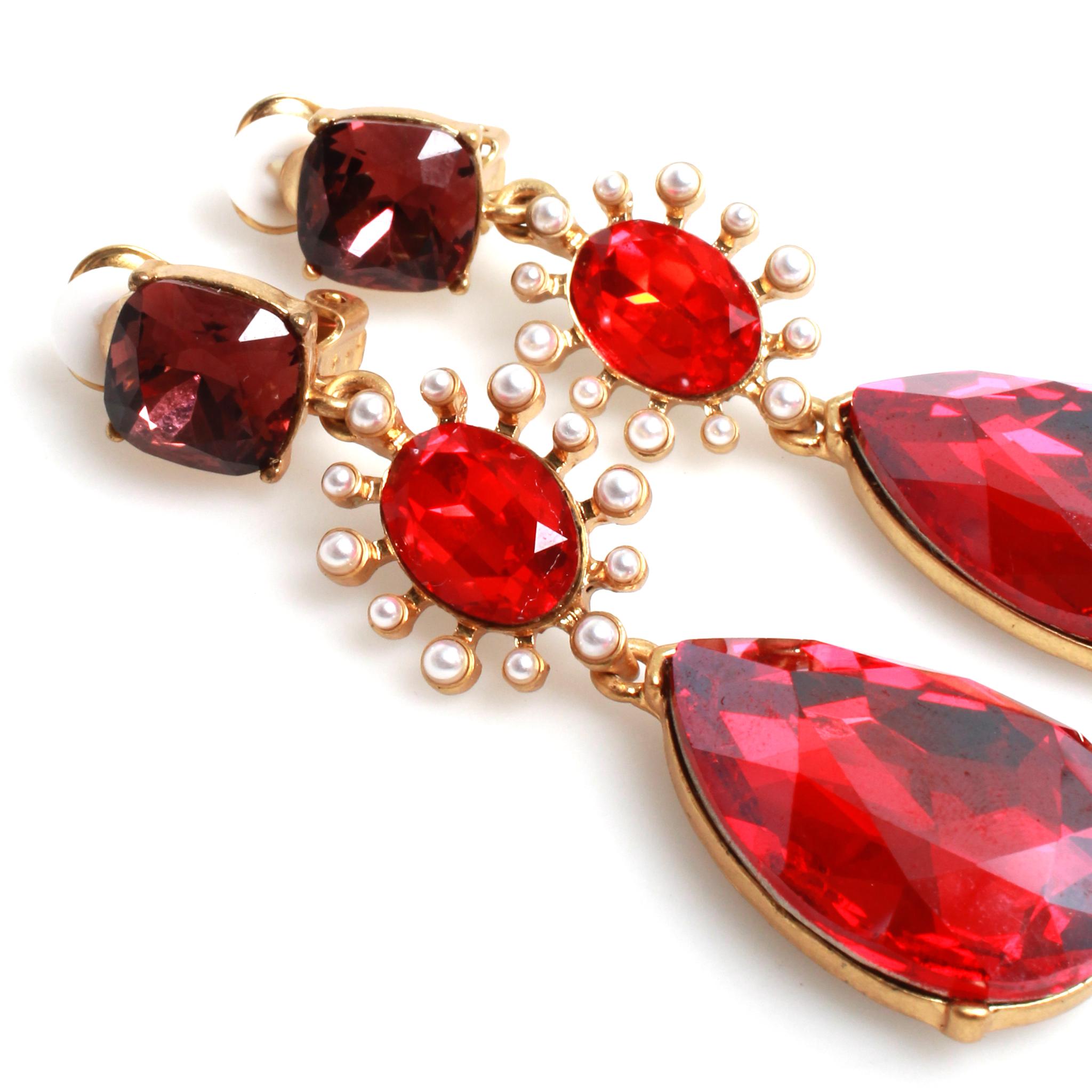 Gold-tone metal Oscar de la Renta ruby colored drop earrings featuring crystals and faux pearl detailing with clip-on closures with rubber comfort pads.
