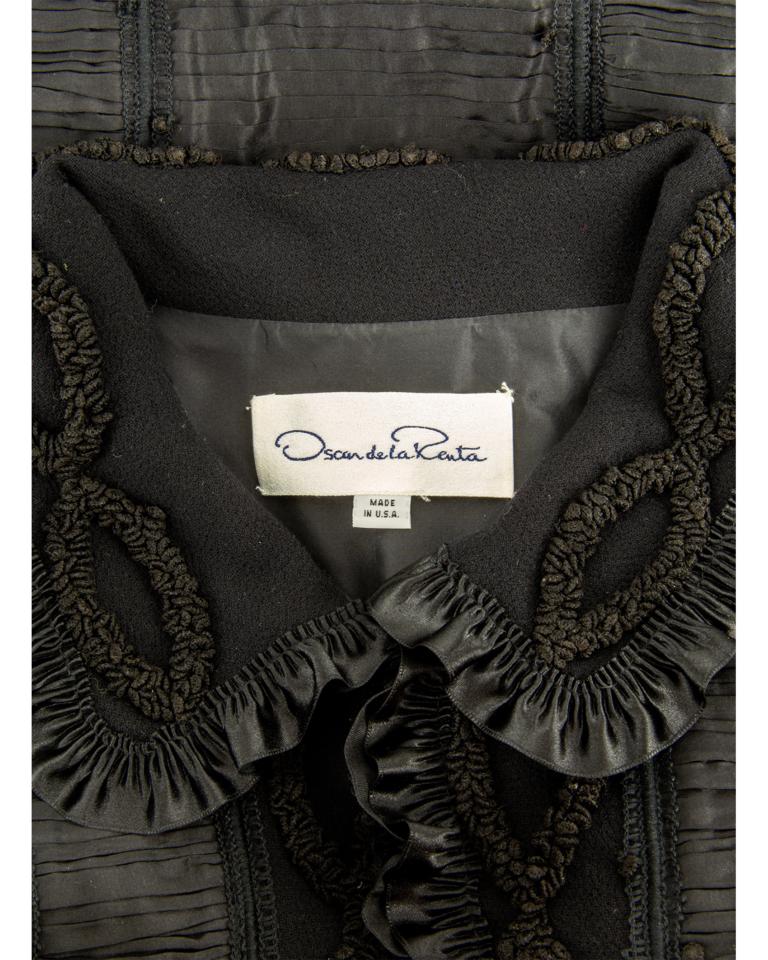 Turn of the century Oscar de la Renta gently padded black silk paper taffeta coat in a vertical band design of irregular horizontal Fortuny-inspired pleats, alternating with boxed pinch pleats and miniature horizontal knife pleats, overlaid with a
