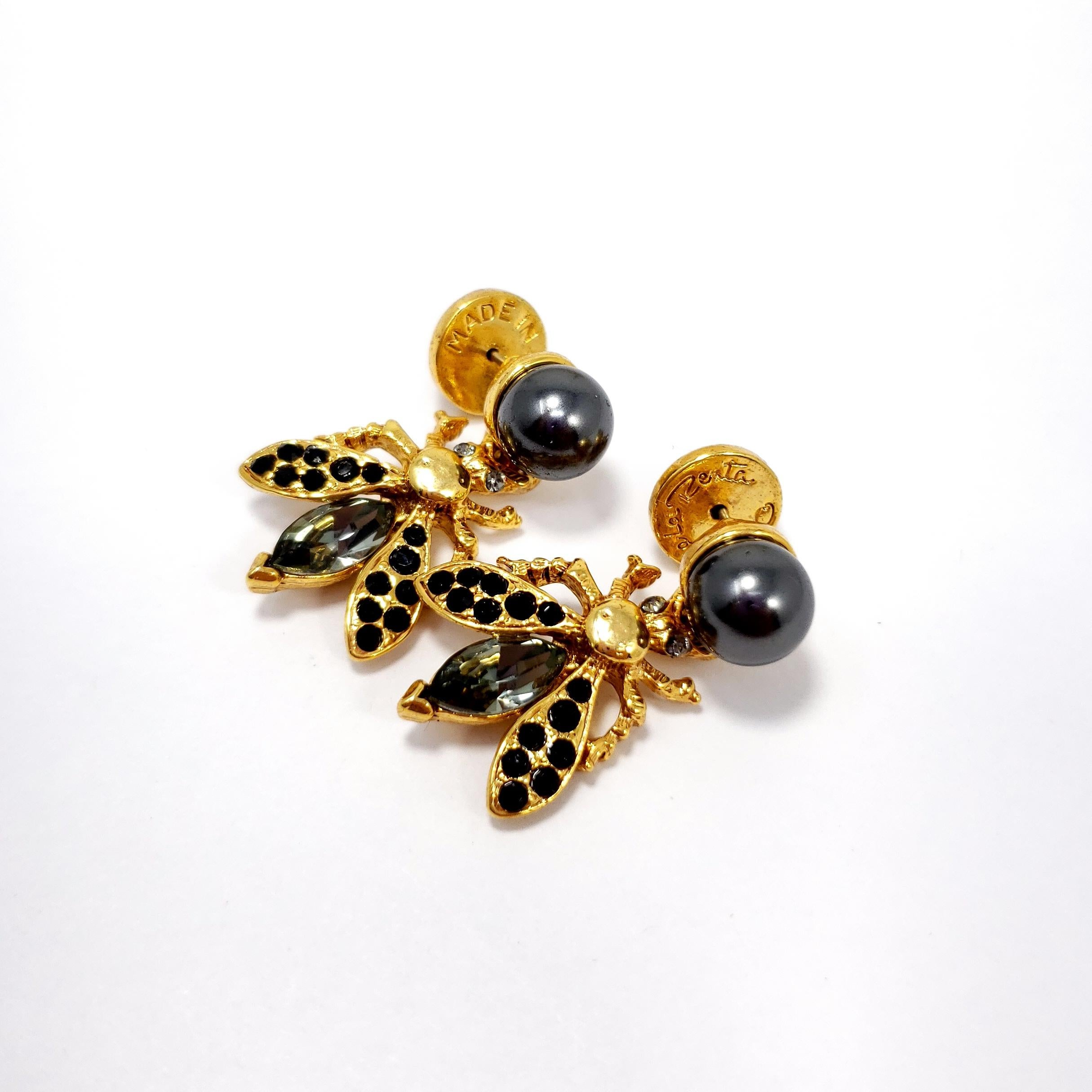Lavish pair of earrings from Oscar de la Renta. A fly accented with black and grey crystals hang off a faux Tahitian pearl. Gold plated.

Hallmarks: Oscar de la Renta, Made in USA
