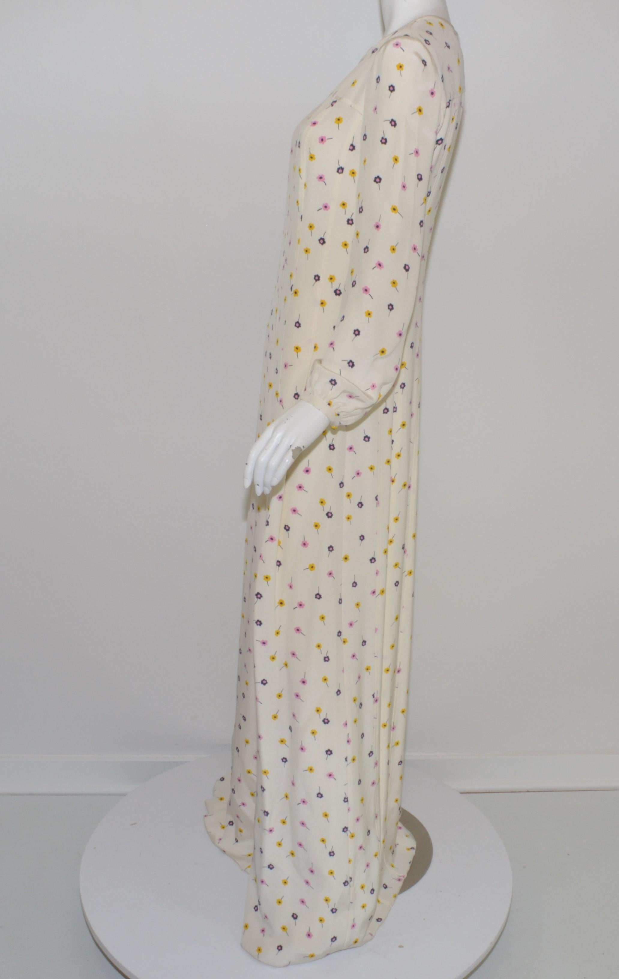 L'abito Oscar De La Renta presenta una stampa floreale su sfondo avorio in uno stile maxi a maniche lunghe. Il vestito ha una cerniera posteriore e una chiusura a gancetto. Nuovo con etichette, taglia 2.

Misure:
Busto 34
Vita 30
Fianchi