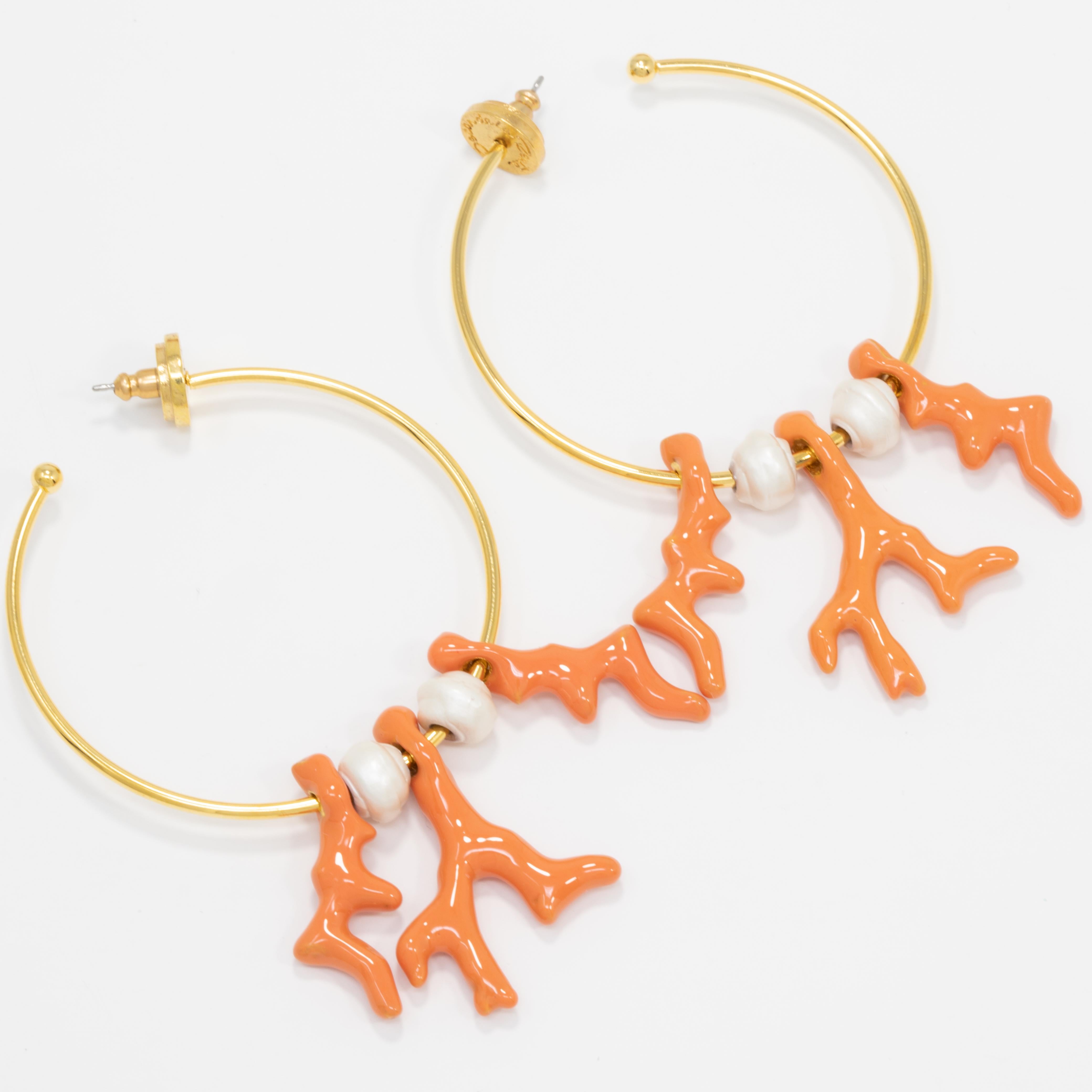A pair of hoop earrings by Oscar de la Renta, accented with dangling enameled coral and faux pearls. Add a golden glow to your outfit!

Gold plated.

Hallmarks: Oscar de la Renta, Made in USA