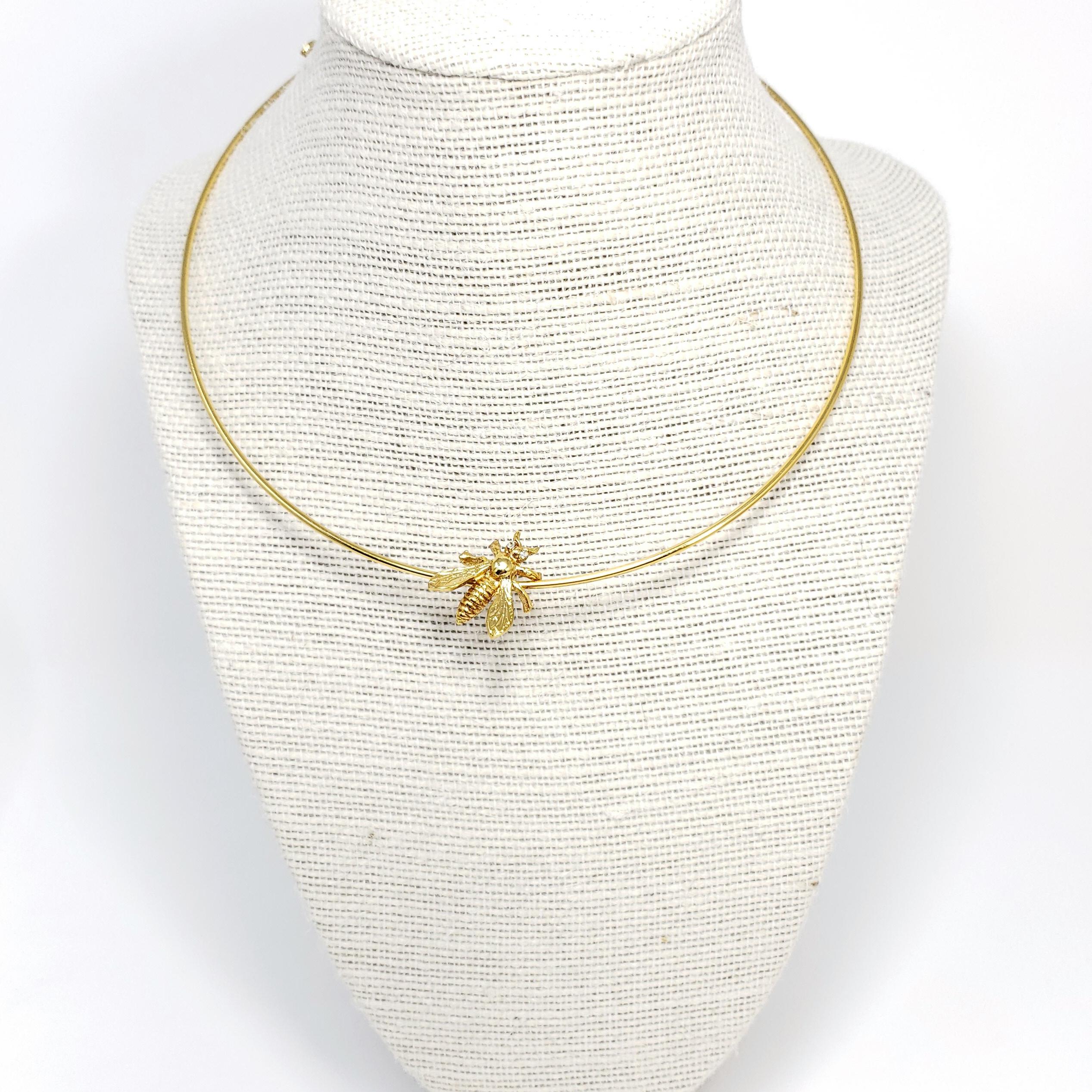 Ein goldenes, mit einer Biene besetztes Halsband von Oscar de la Renta.

Vergoldet.

Markenzeichen: Oscar de la Renta, Hergestellt in den USA
