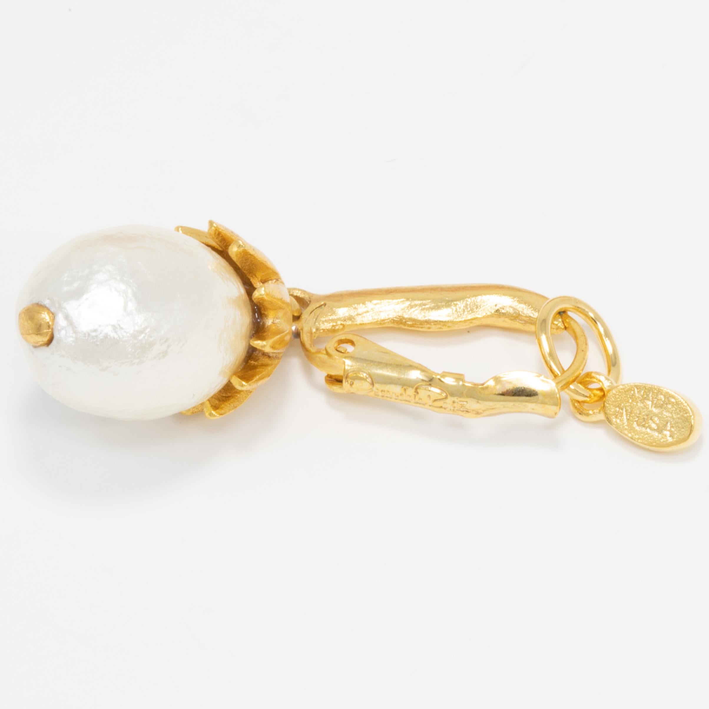 A pair of dangling earrings by Oscar de la Renta. a faux pearl hangs off of each gold-plated, hinged, French hook.

Marks / Hallmarks / Signs: Ocar de la Renta, Made in USA

